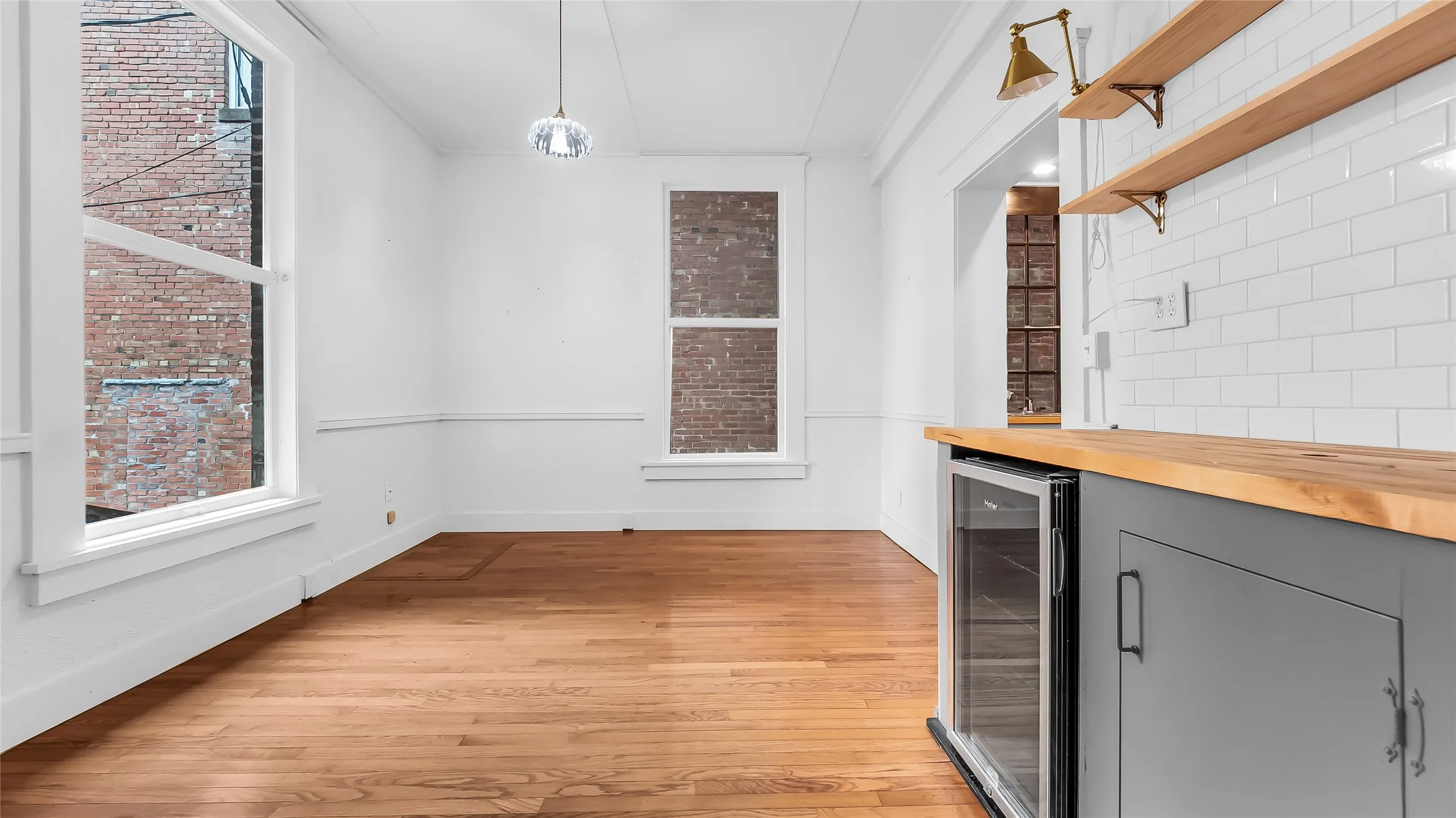 Hardwood flooring, crisp white walls with wainscoting, and large windows