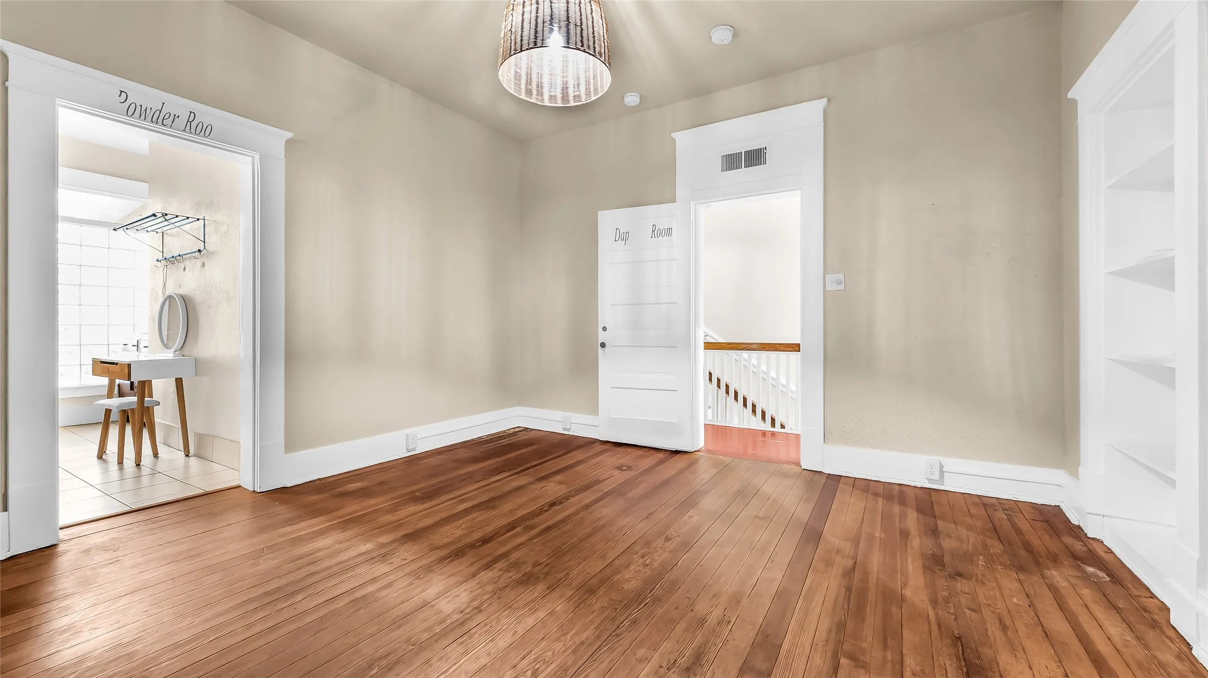 Wood-finish flooring, built-in shelving, and a decorative ceiling light fixture