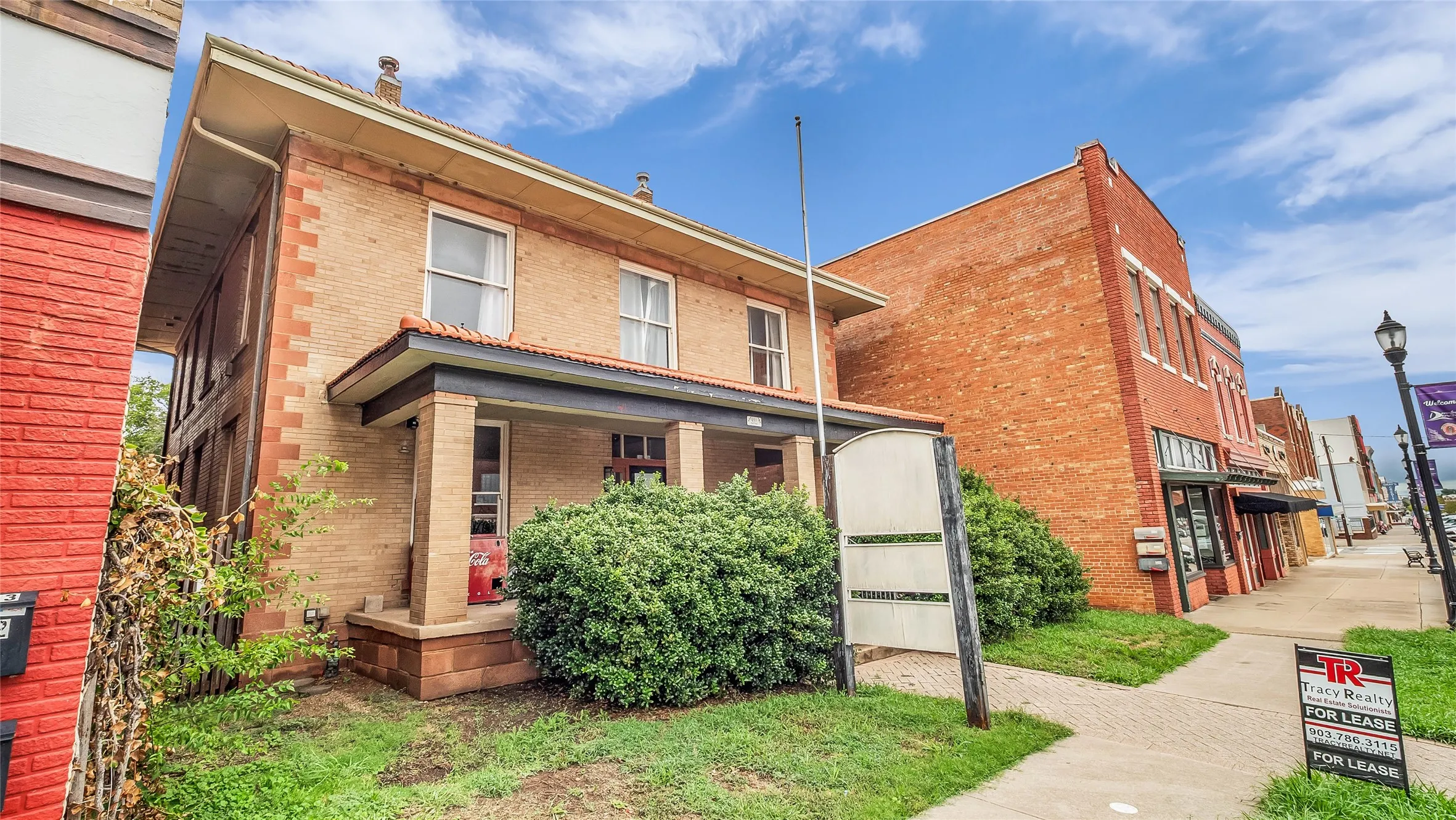 Brick facade with light-colored trim and a covered front porch featuring columns