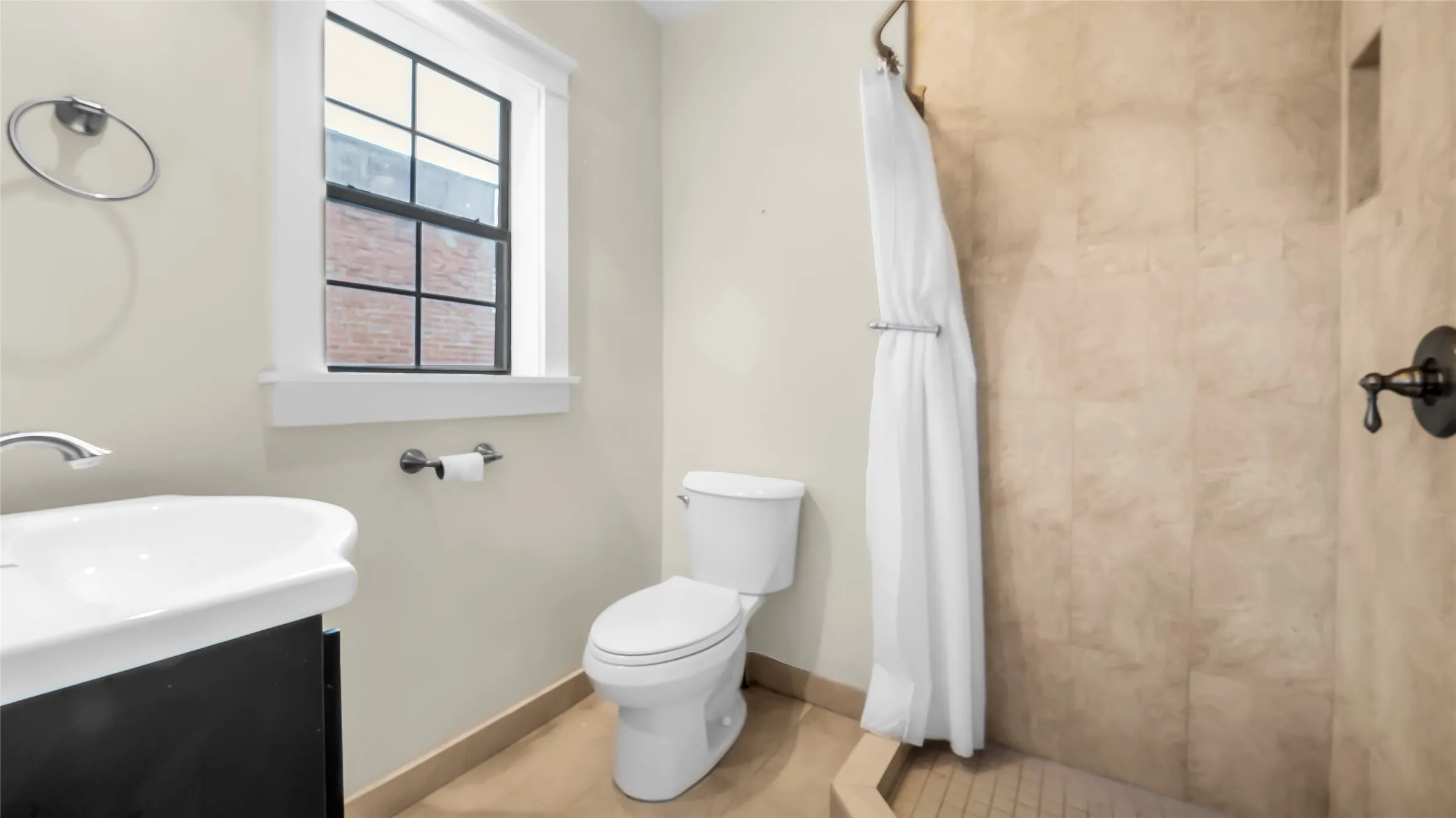 Full bathroom featuring a window, tile flooring, and a tiled shower stall with oil-rubbed bronze fixtures