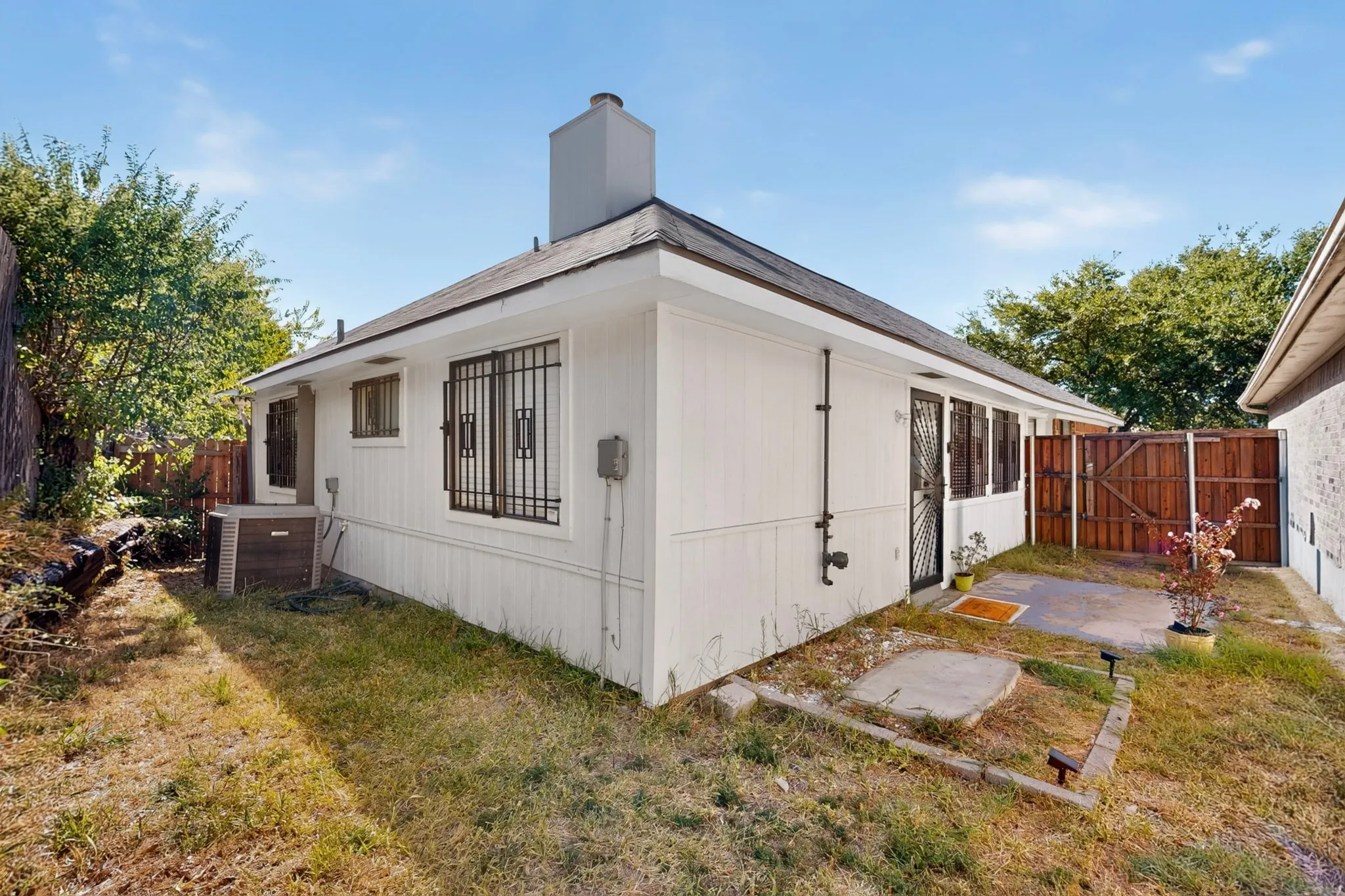 White siding exterior with a dark shingle roof, a dedicated patio area, and a privacy​​‌​​​​‌​​‌‌​‌‌​​​‌‌​‌​‌​‌​​​‌​​ fence