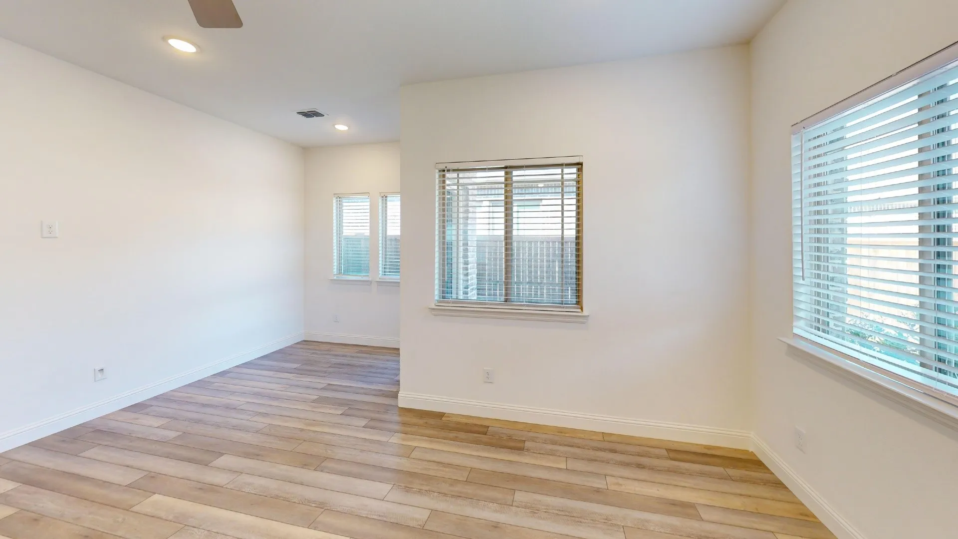 Recessed lighting, wood-finish flooring, multiple windows with blinds, and a ceiling fan