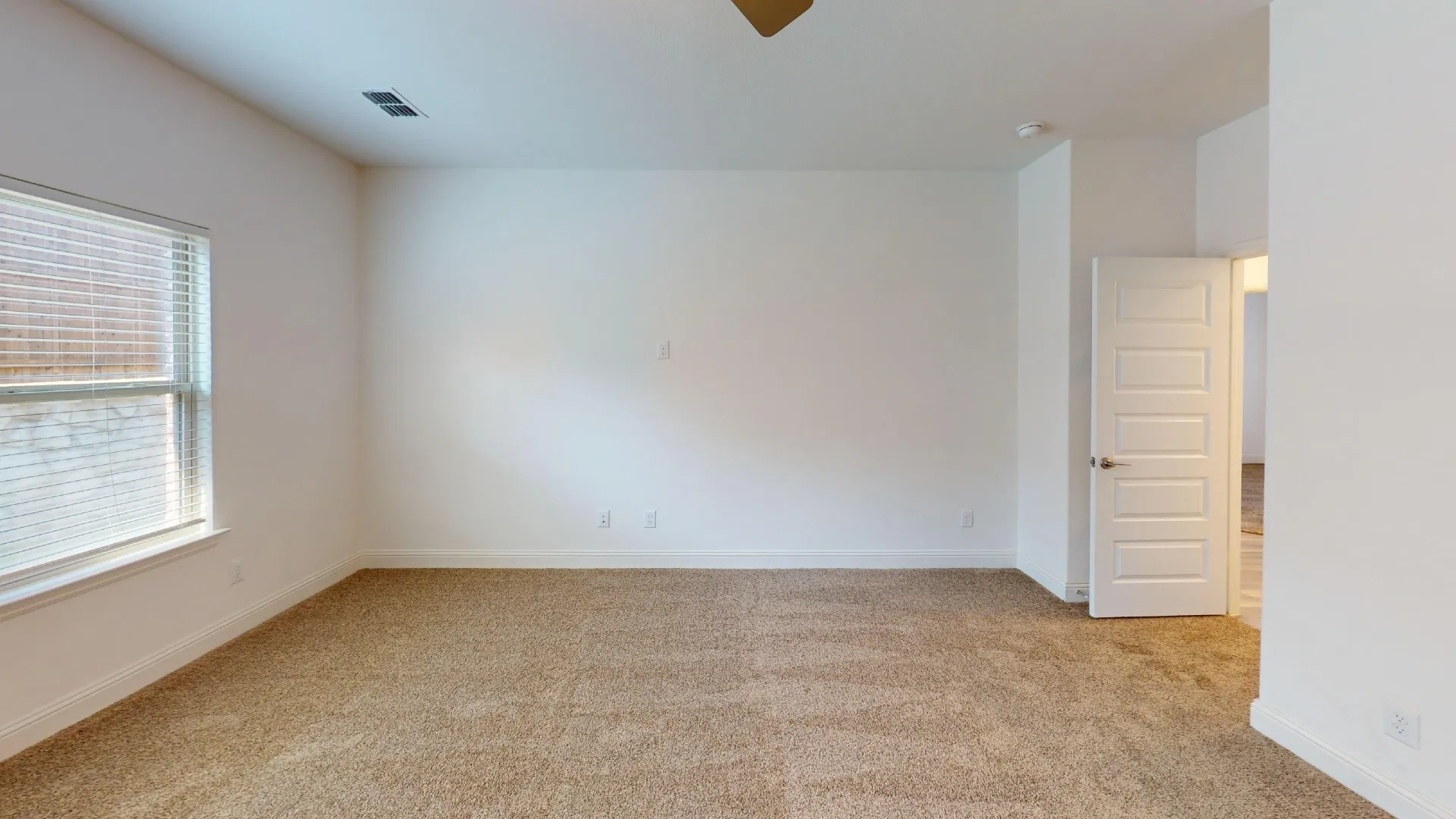 Recessed lighting, light tan carpeting, white interior door with panel detailing, and a window with blinds