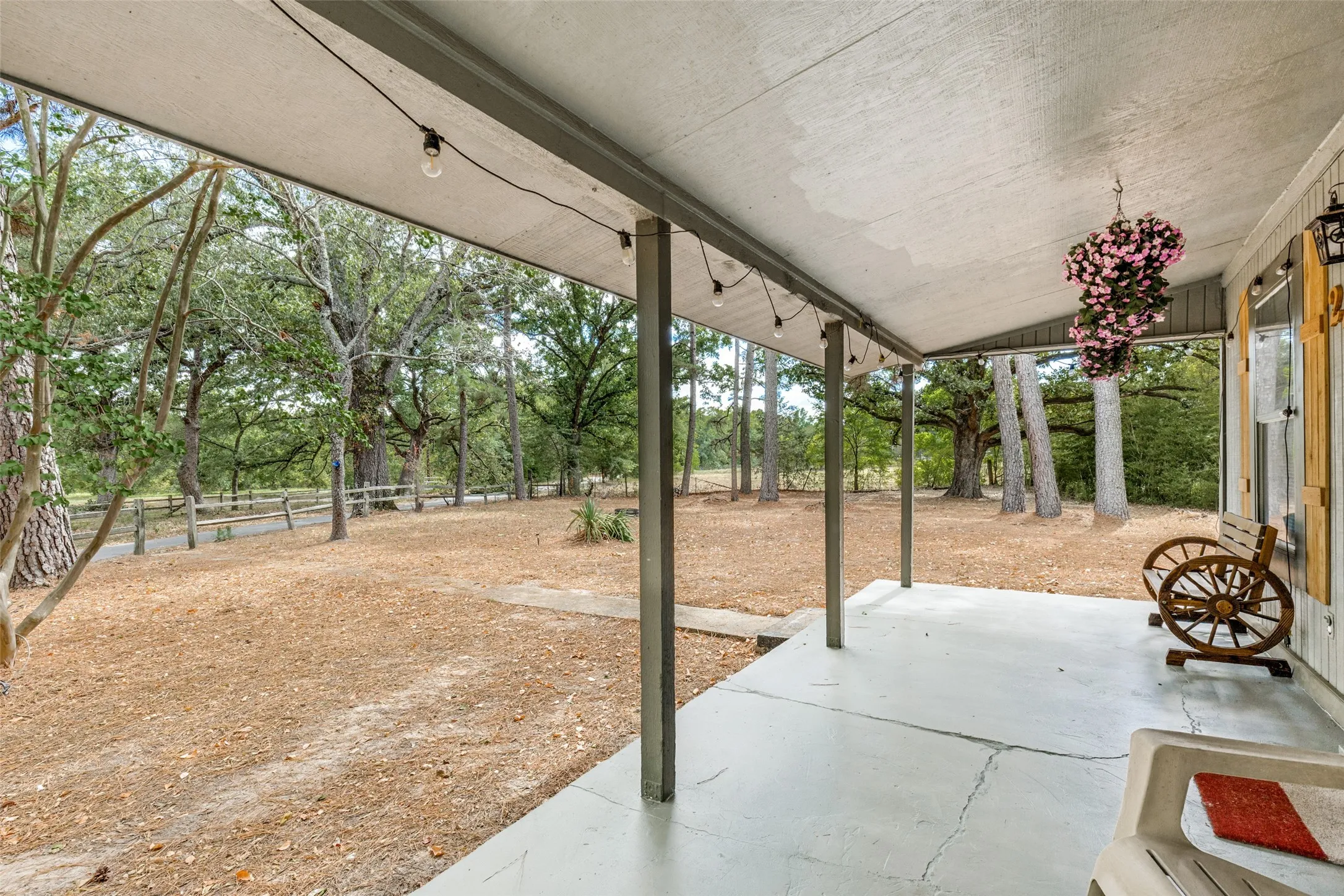 Covered porch with concrete flooring and exposed beam ceiling