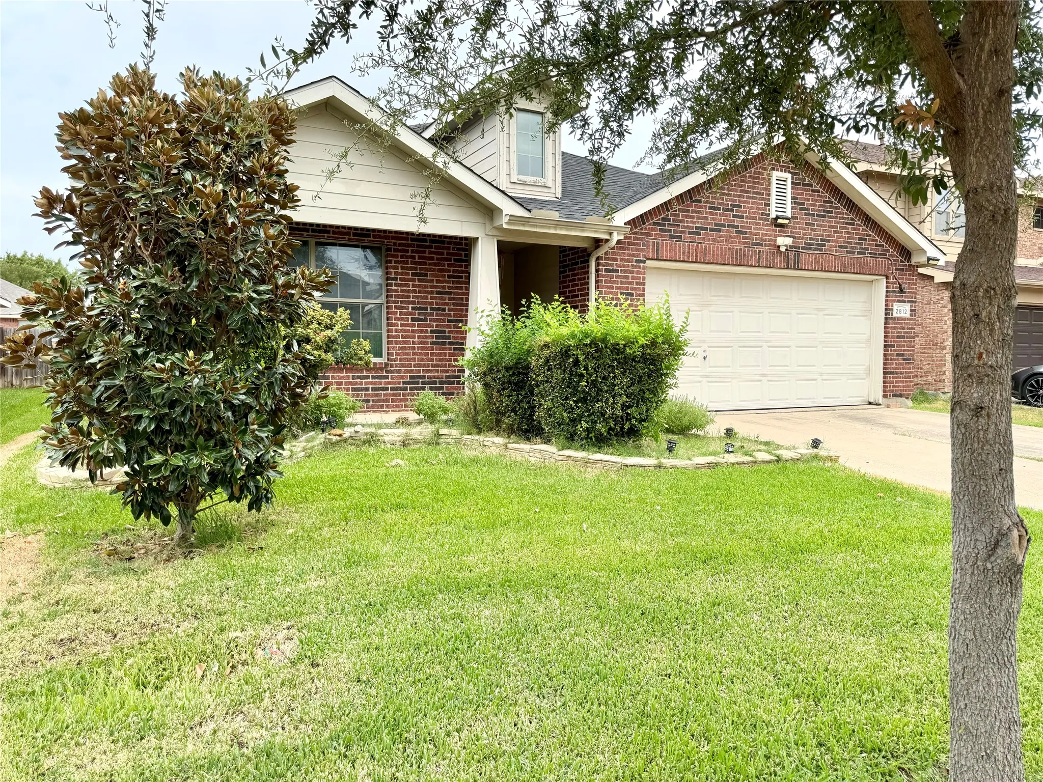 Brick and siding exterior with an attached garage