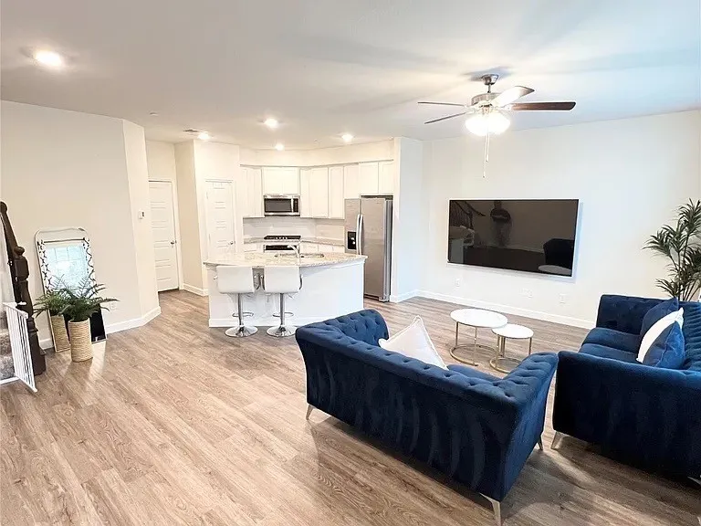 Living area featuring baseboards, light wood-style flooring, recessed lighting, and a ceiling fan