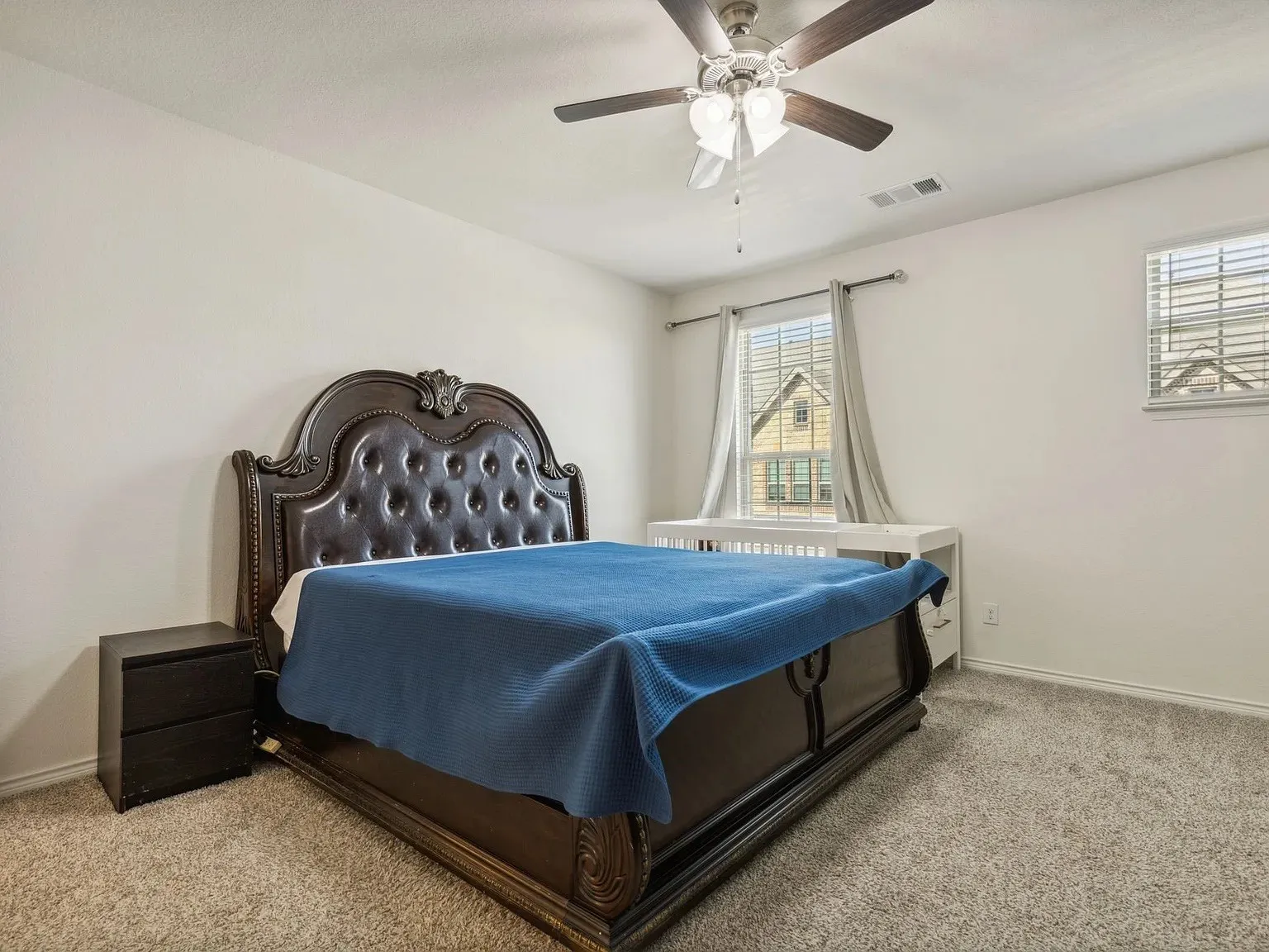 Bedroom featuring baseboards, visible vents, multiple windows, and light colored carpet