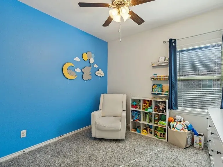 Rec room featuring carpet flooring, a ceiling fan, and baseboards