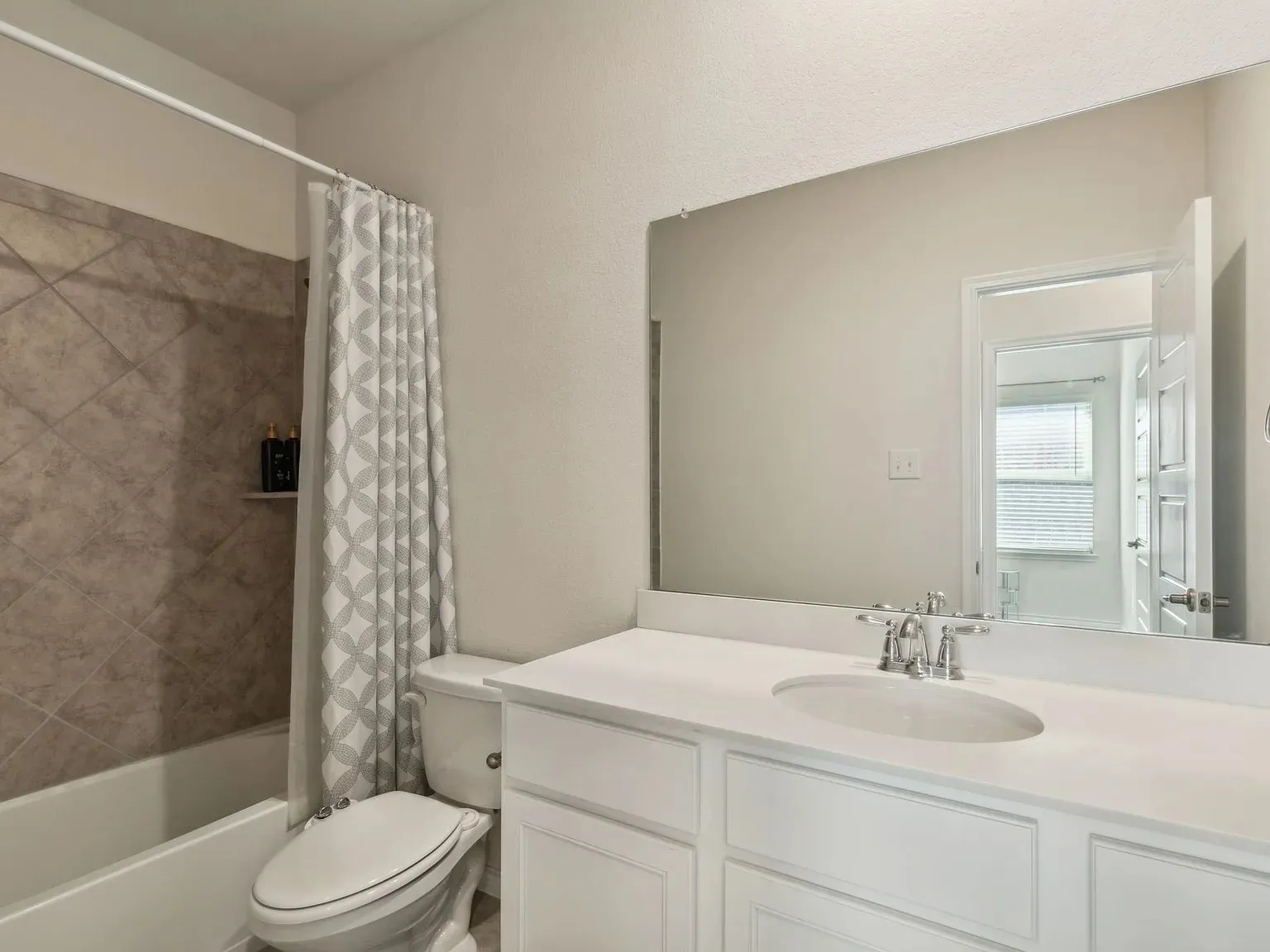 Bathroom featuring toilet, vanity, and shower / bath combo