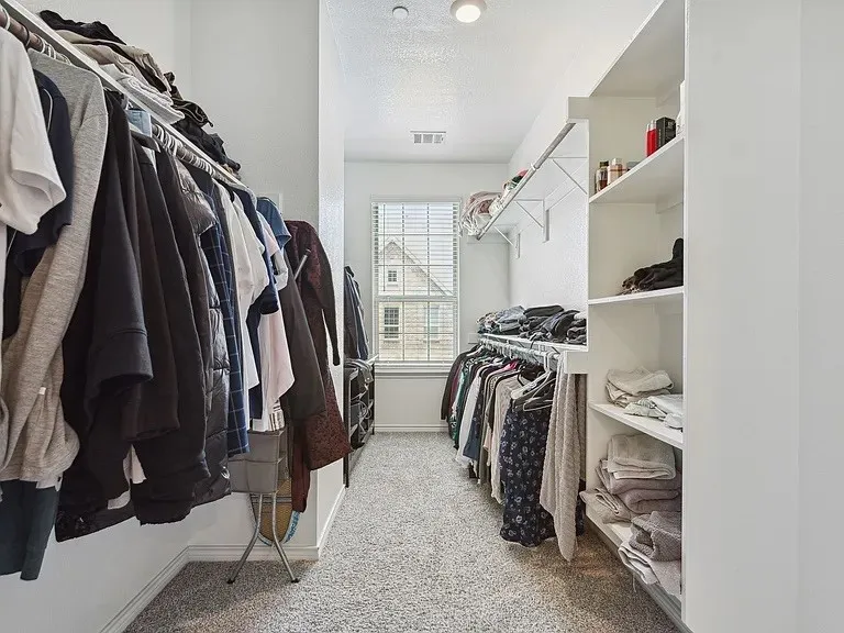 Walk in closet featuring visible vents and carpet