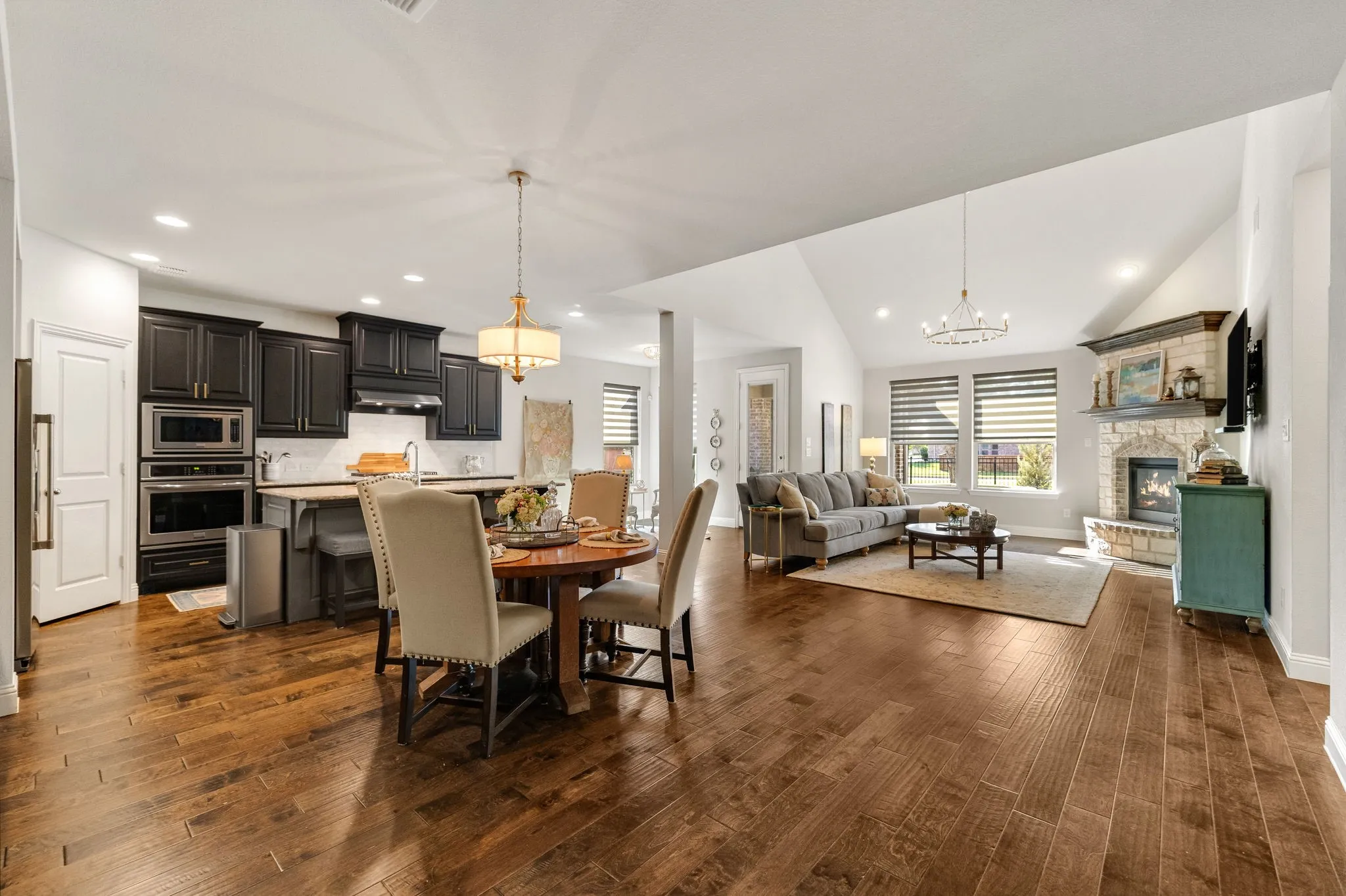 Open-concept dining to kitchen, living room, and breakfast room.