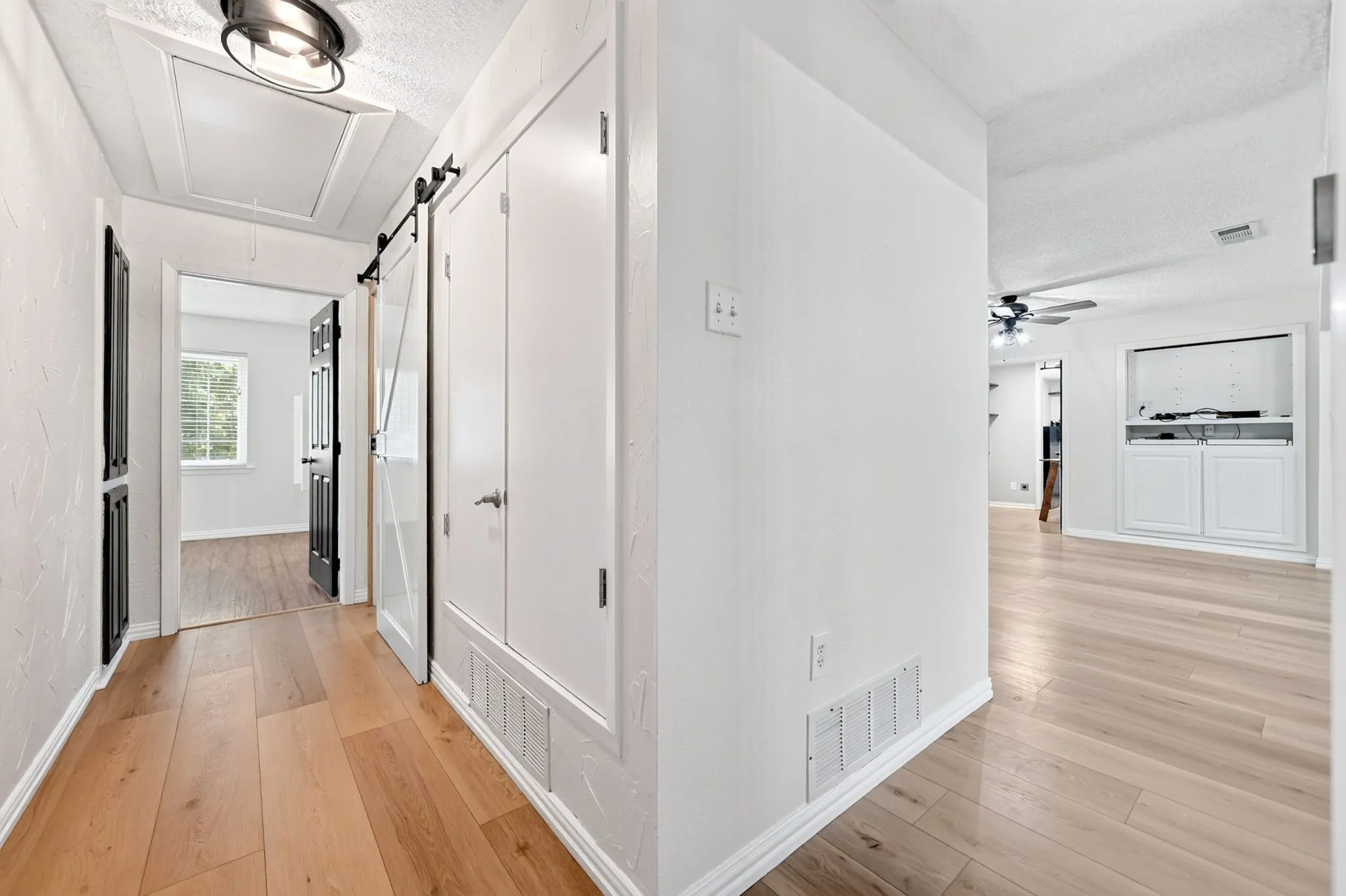 Wood-finish flooring throughout, white interior doors, and built-in white cabinetry