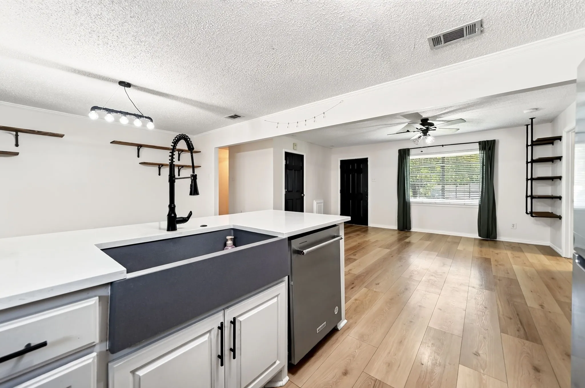 Kitchen island with a farmhouse sink and pull-down faucet