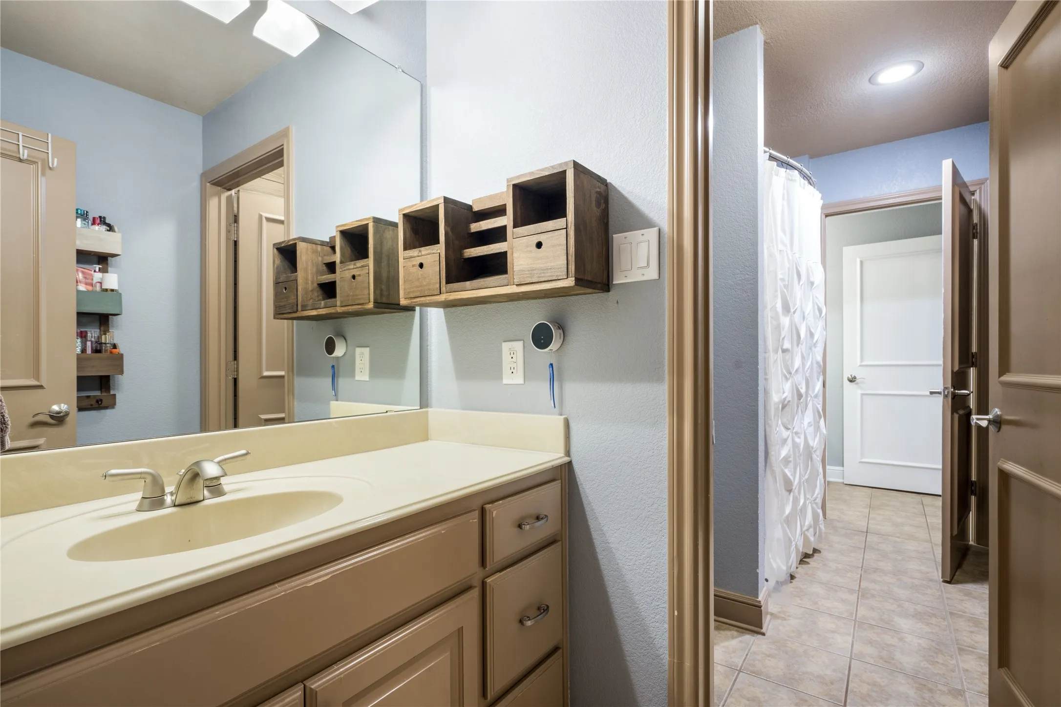 Single vanity with integrated sink, brushed nickel faucet, and under-sink cabinetry