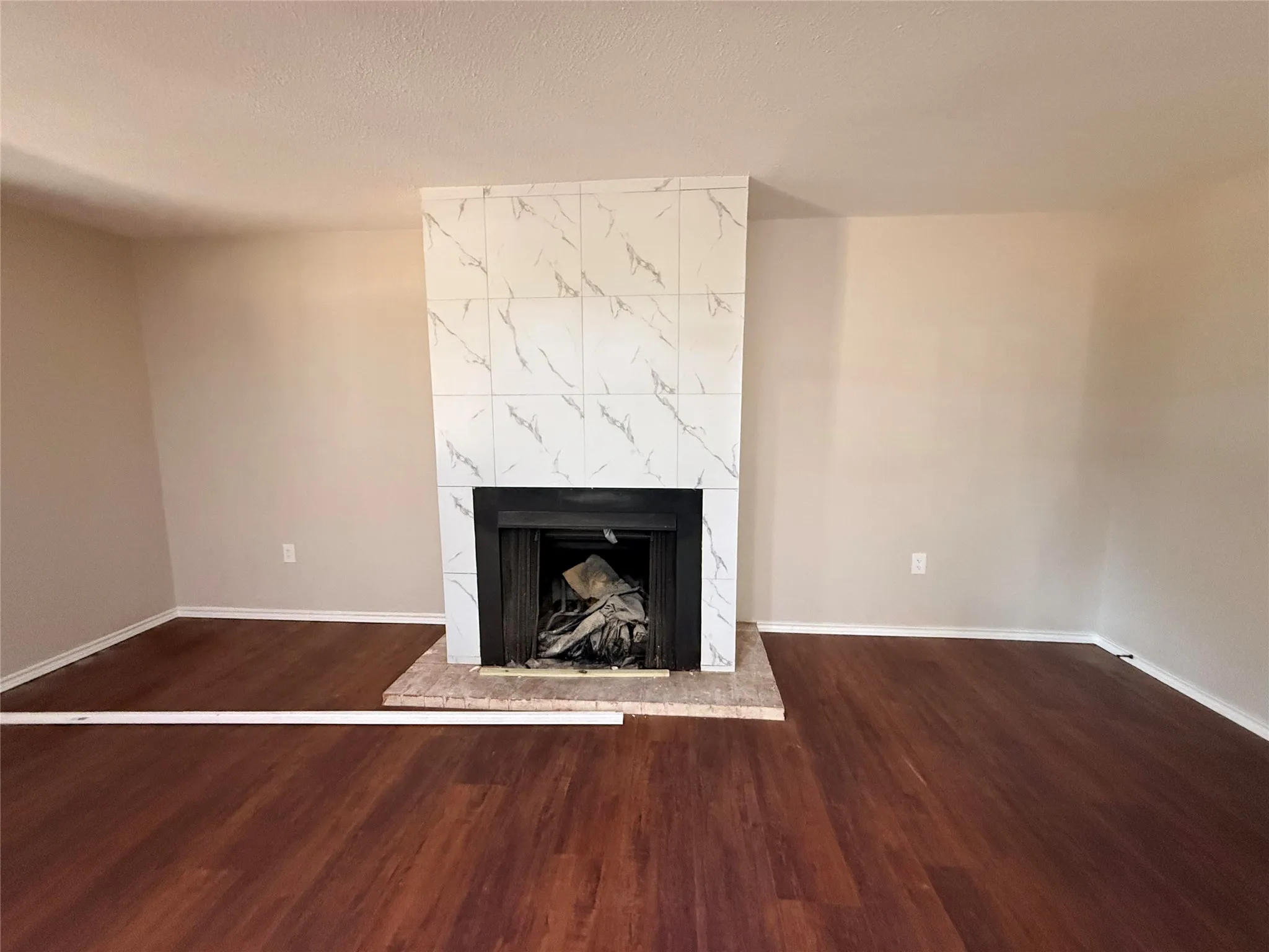 Fireplace with a tiled surround, hearth, and dark firebox