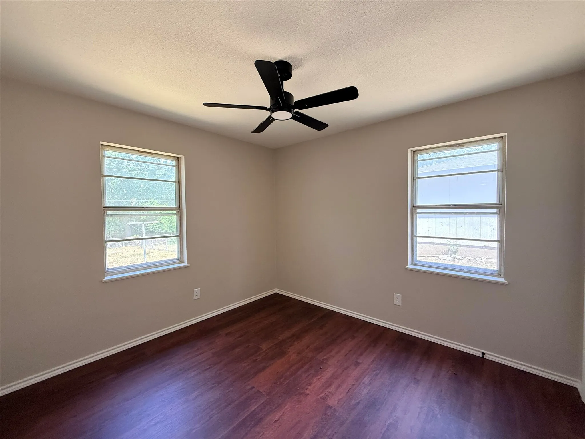 Wood-finish flooring with neutral wall tones and a ceiling fan