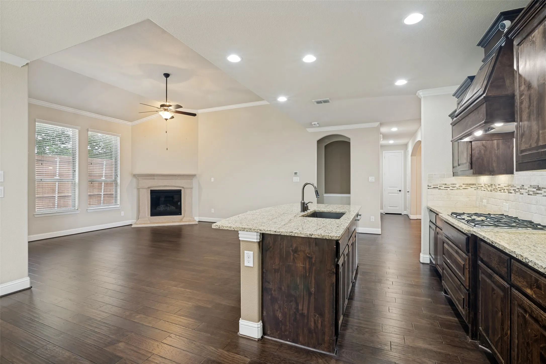 Living area and kitchen as seen from breakfast area. Gas log fireplace with cast stone surround in background.
