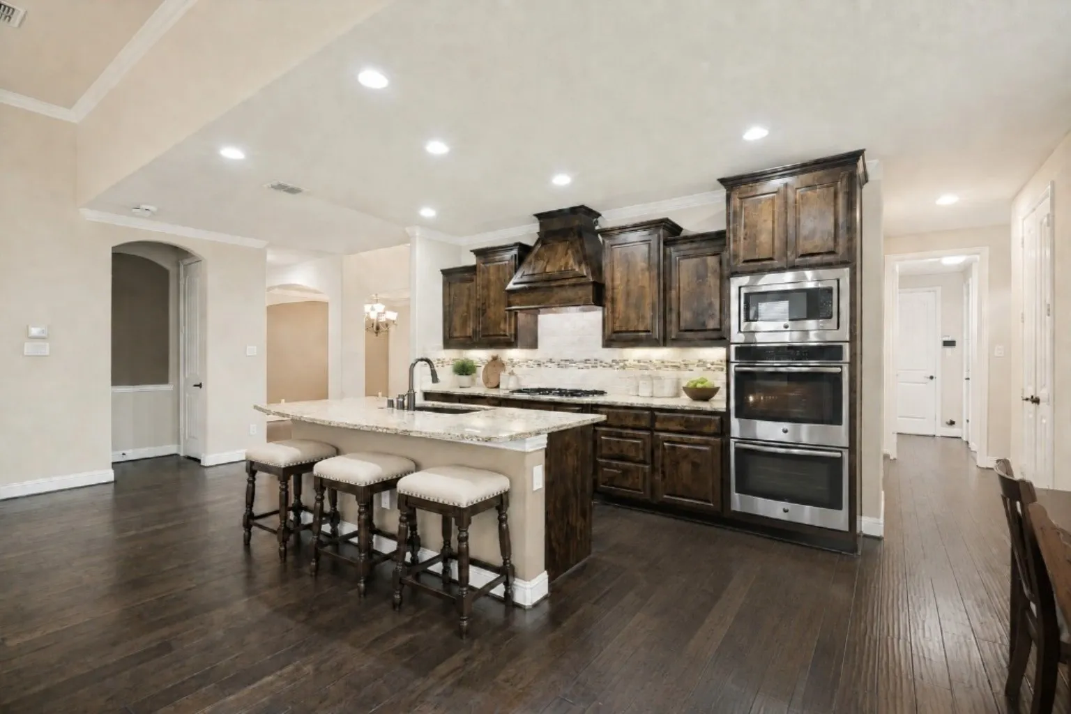 Open kitchen with large island for prep and eating (virtually staged).