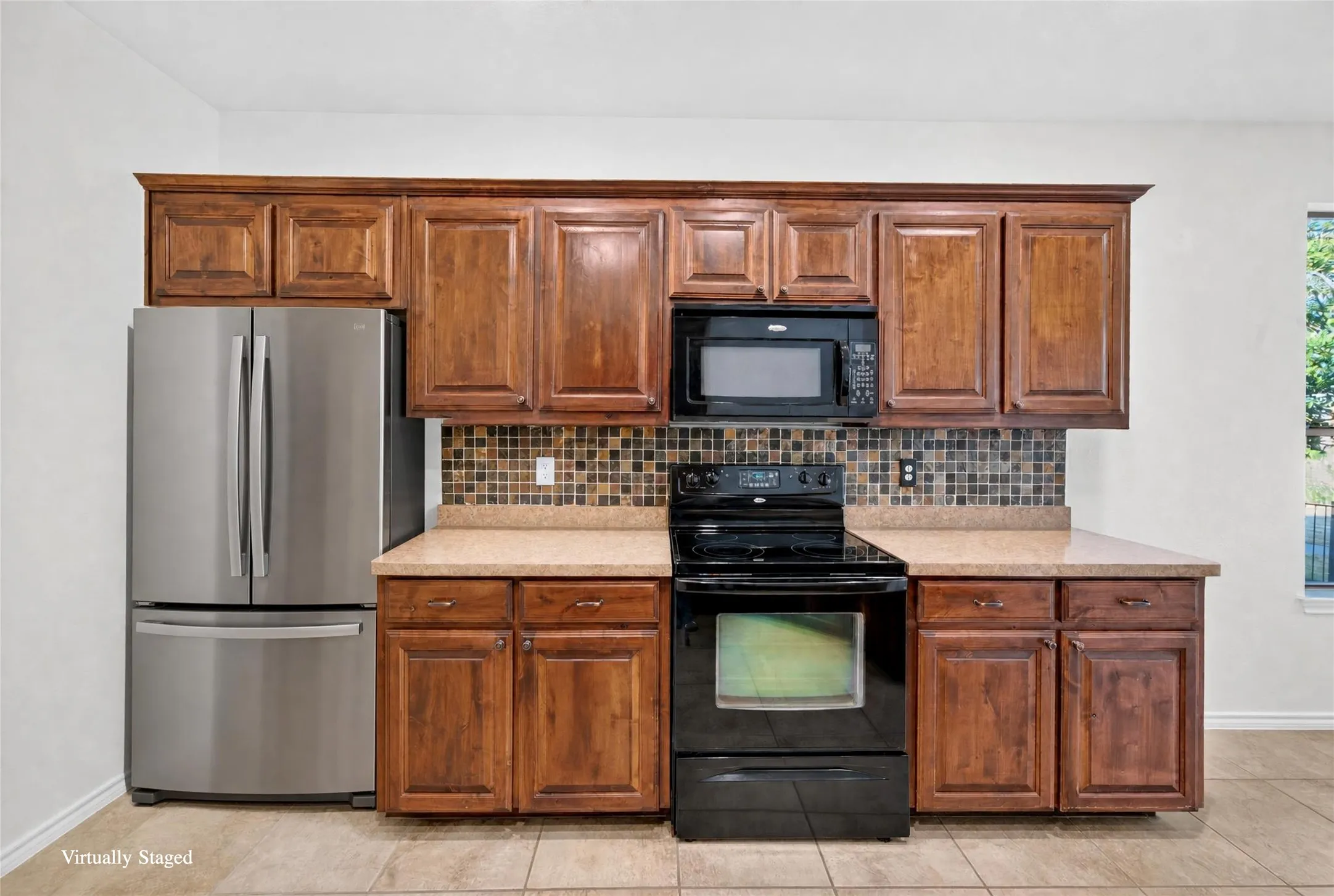 Wood-finish cabinetry complemented by light-toned countertops and a mosaic tile backsplash
