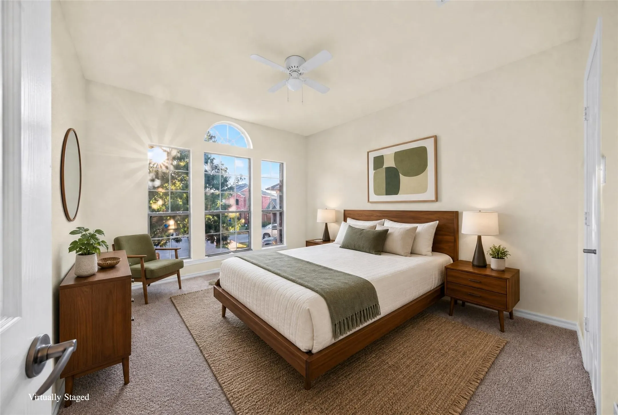 Carpeted bedroom featuring an arched window, three panel windows, and a ceiling fan