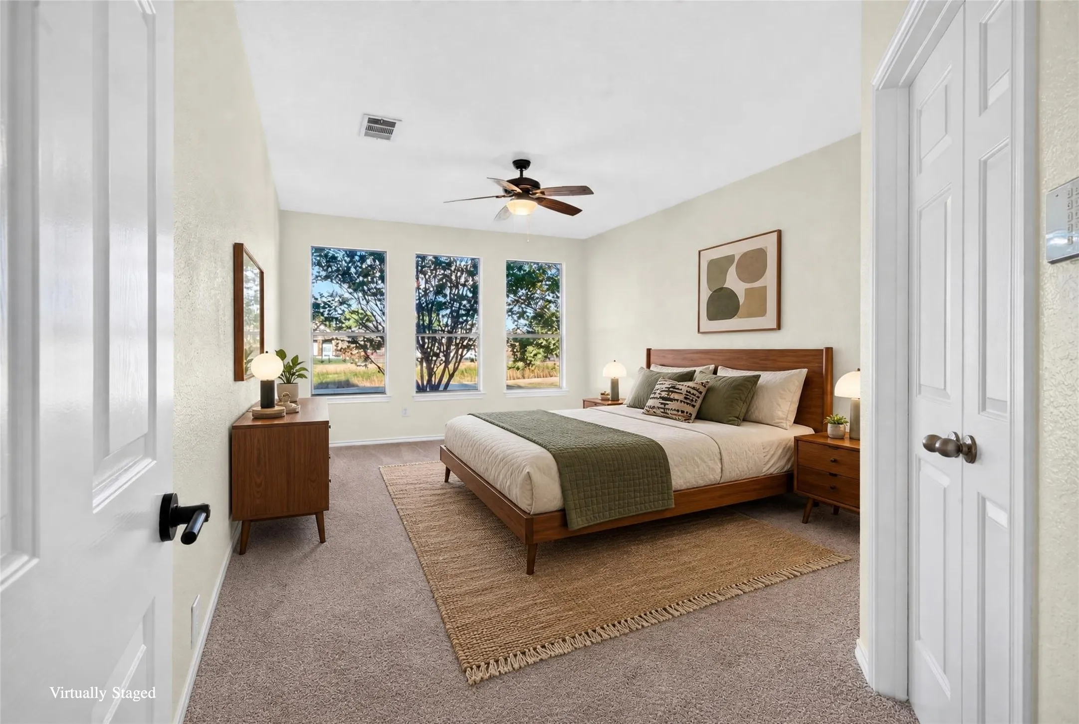 Recessed ceiling fan with integrated lighting, three bright windows, textured wall finish, and carpeted flooring