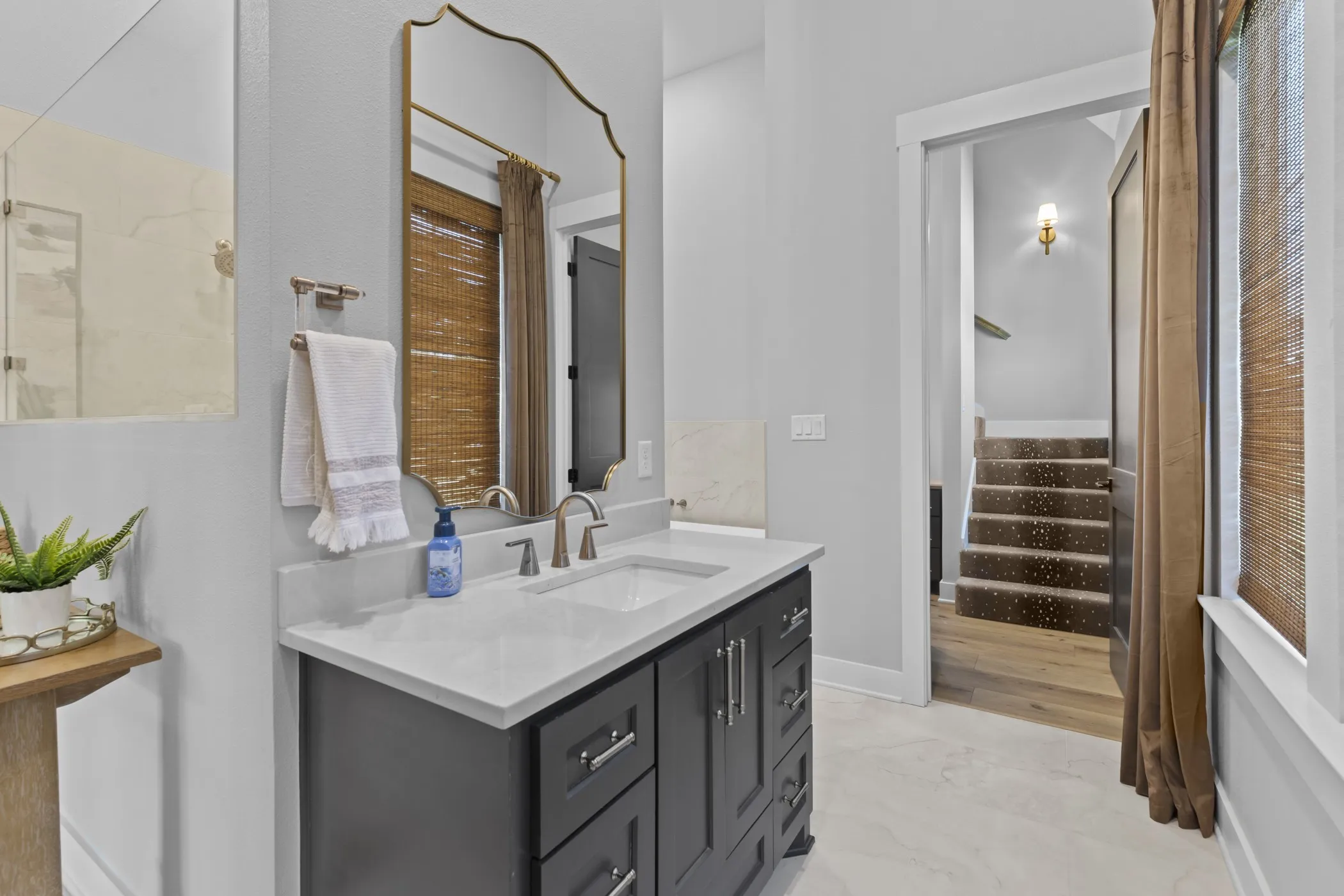 Vanity with a light-toned countertop, brushed nickel faucet, and dark cabinetry