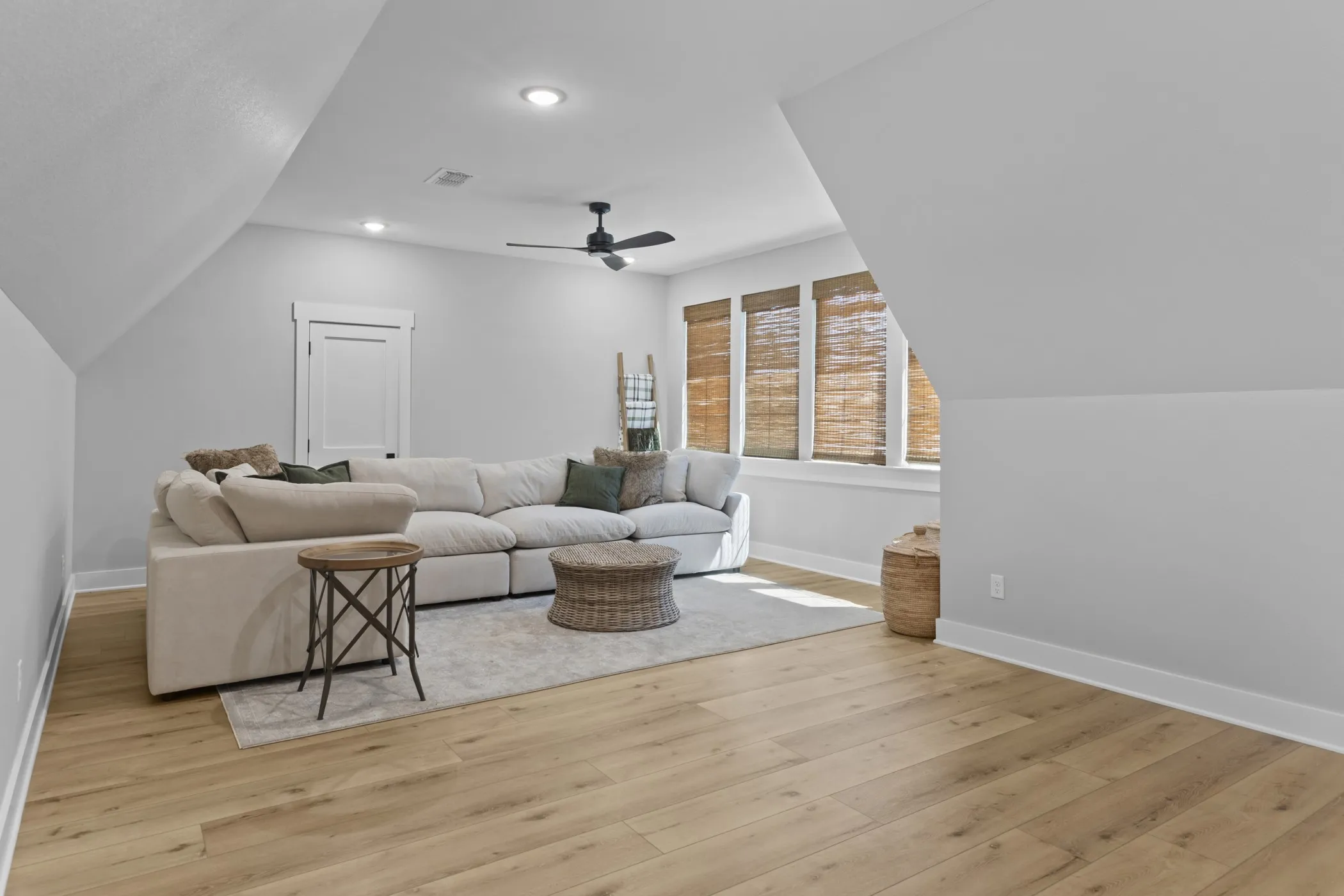 Wood-finish flooring, recessed lighting, and a ceiling fan create a comfortable atmosphere