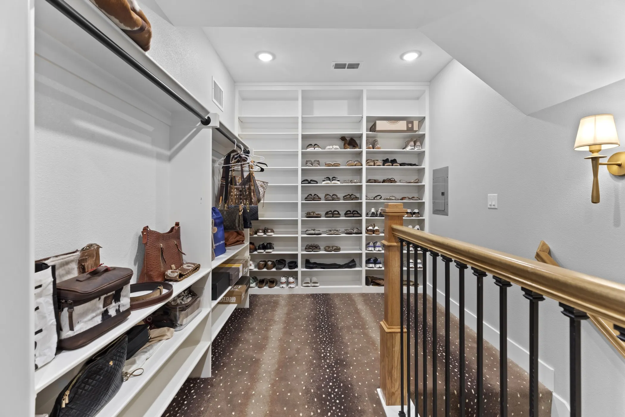 Custom built-in shelving, recessed lighting, wood-finish flooring, and a metal and wood balustrade