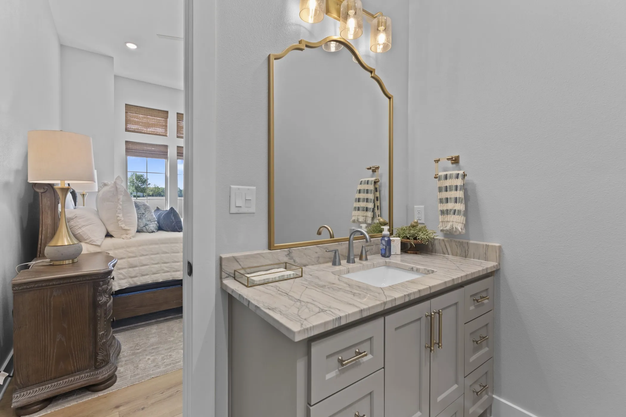 Single vanity with a light gray cabinet, a neutral-toned countertop, and an undermount sink