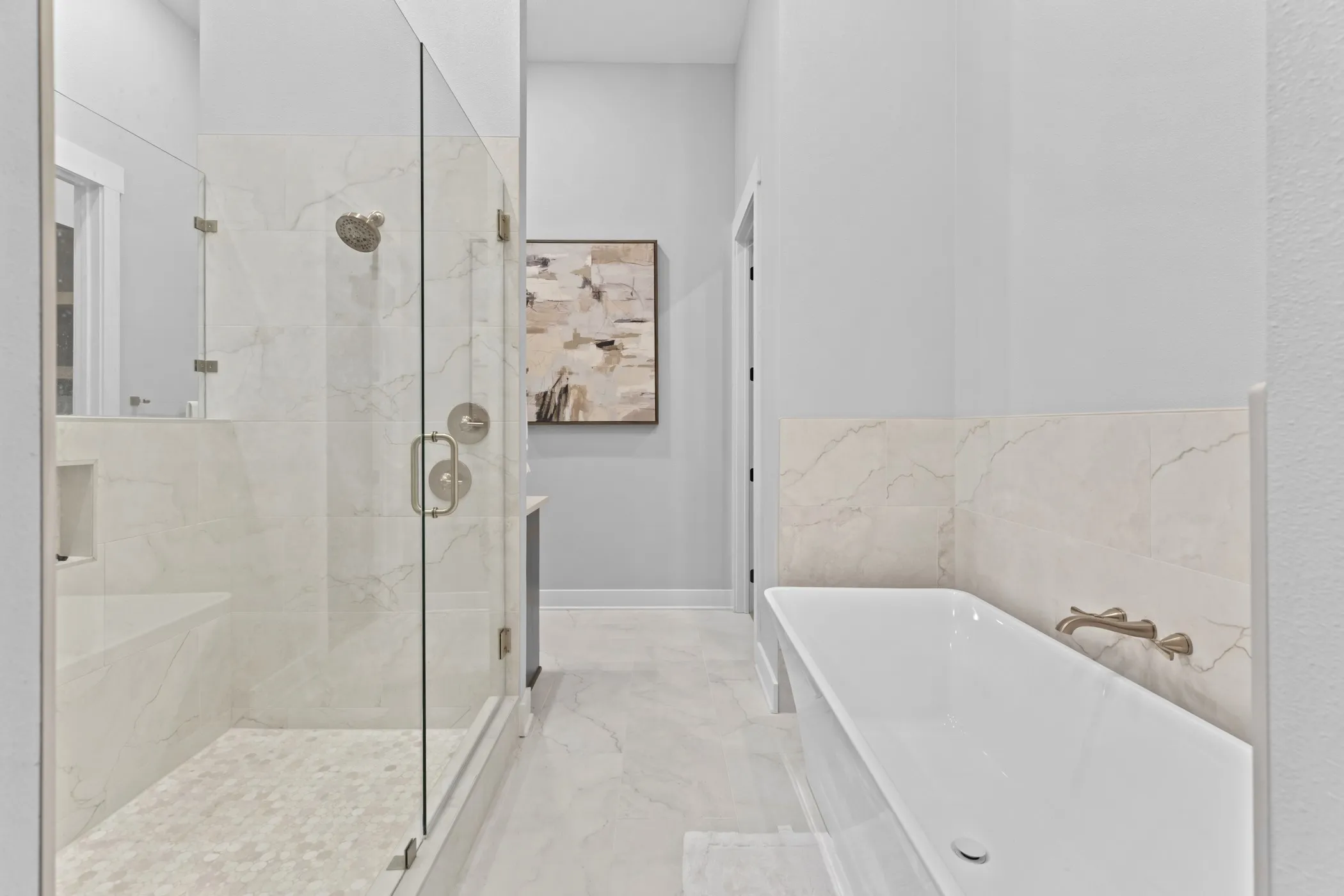 Walk-in shower with clear glass enclosure, integrated bench, and mosaic tile floor