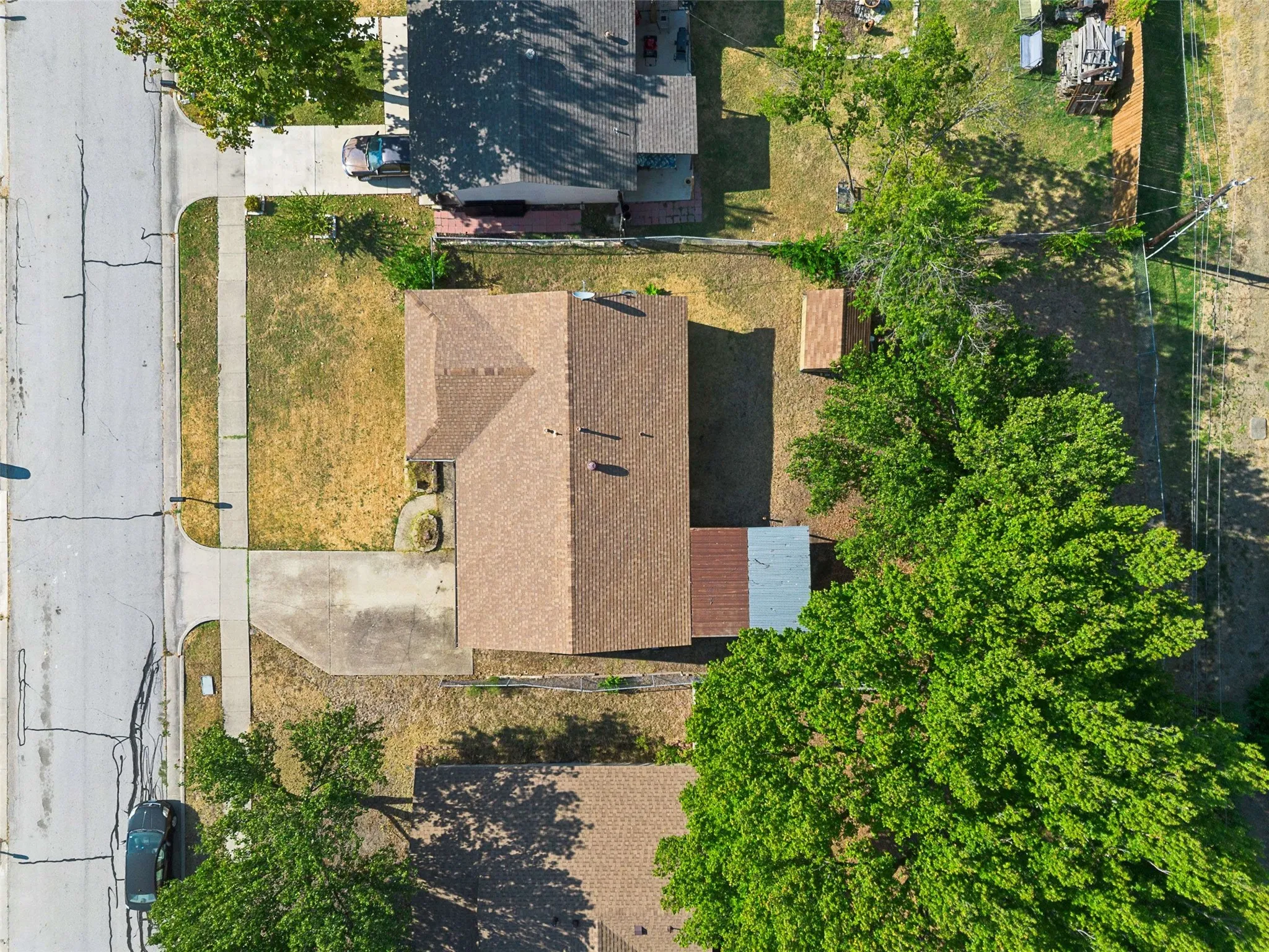 Property featuring a gabled roof, paved driveway, and established trees