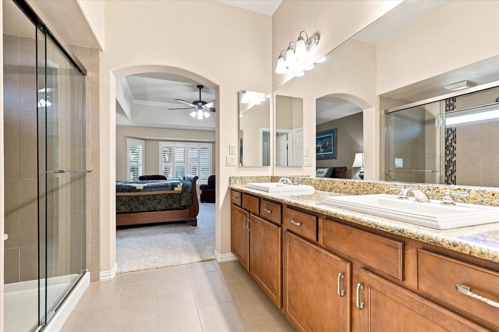 Dual vanity with granite countertop, and wood-finish cabinetry