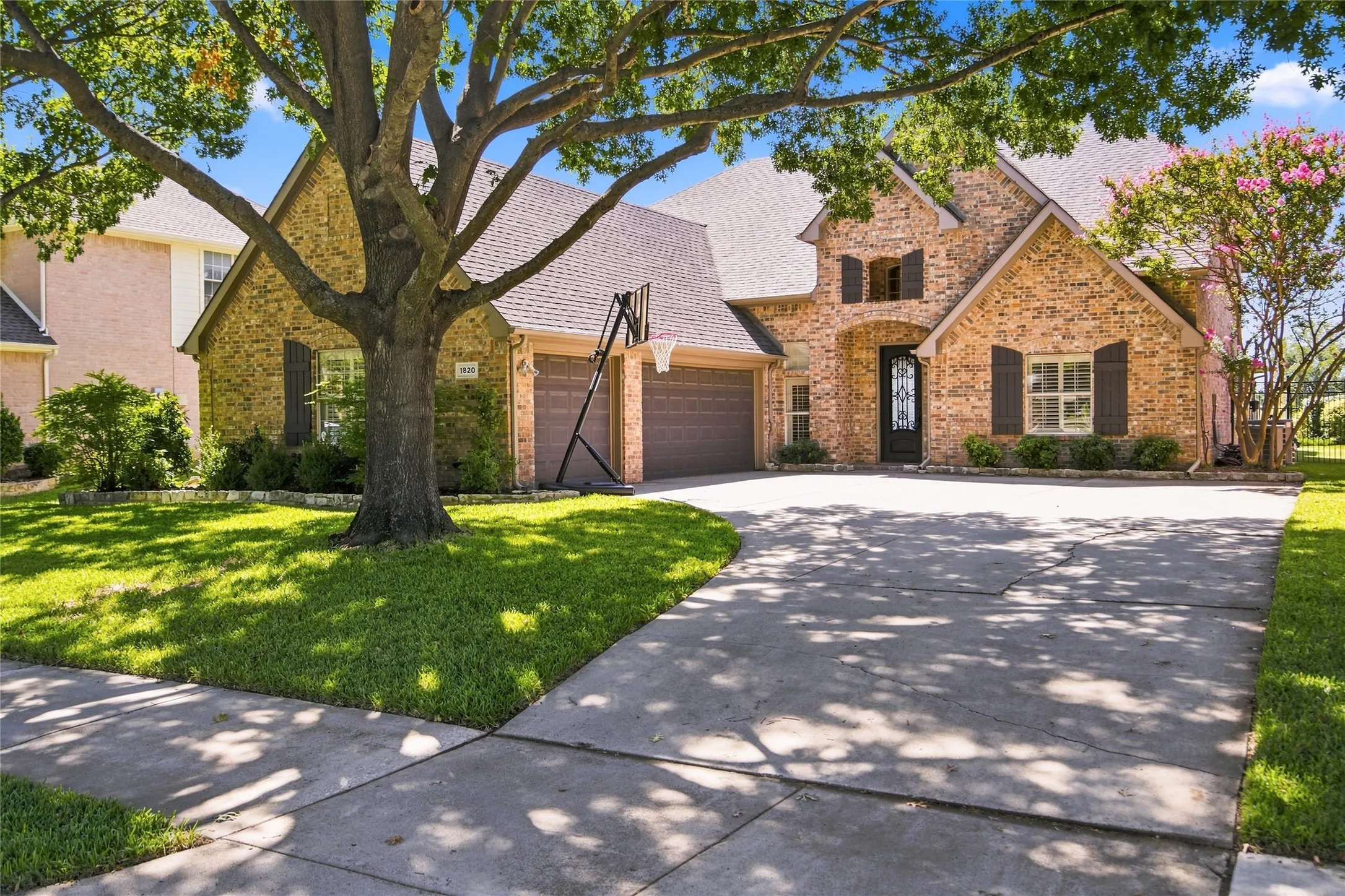Brick exterior with multiple gables, arched entry, and dark wood shutters