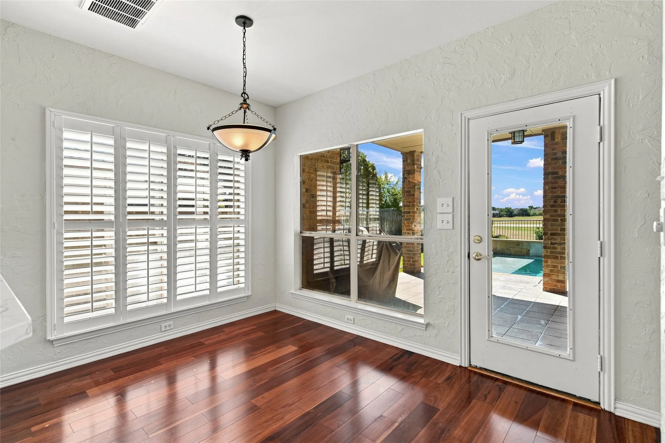 Dining area with backyard views of pool and golf course.