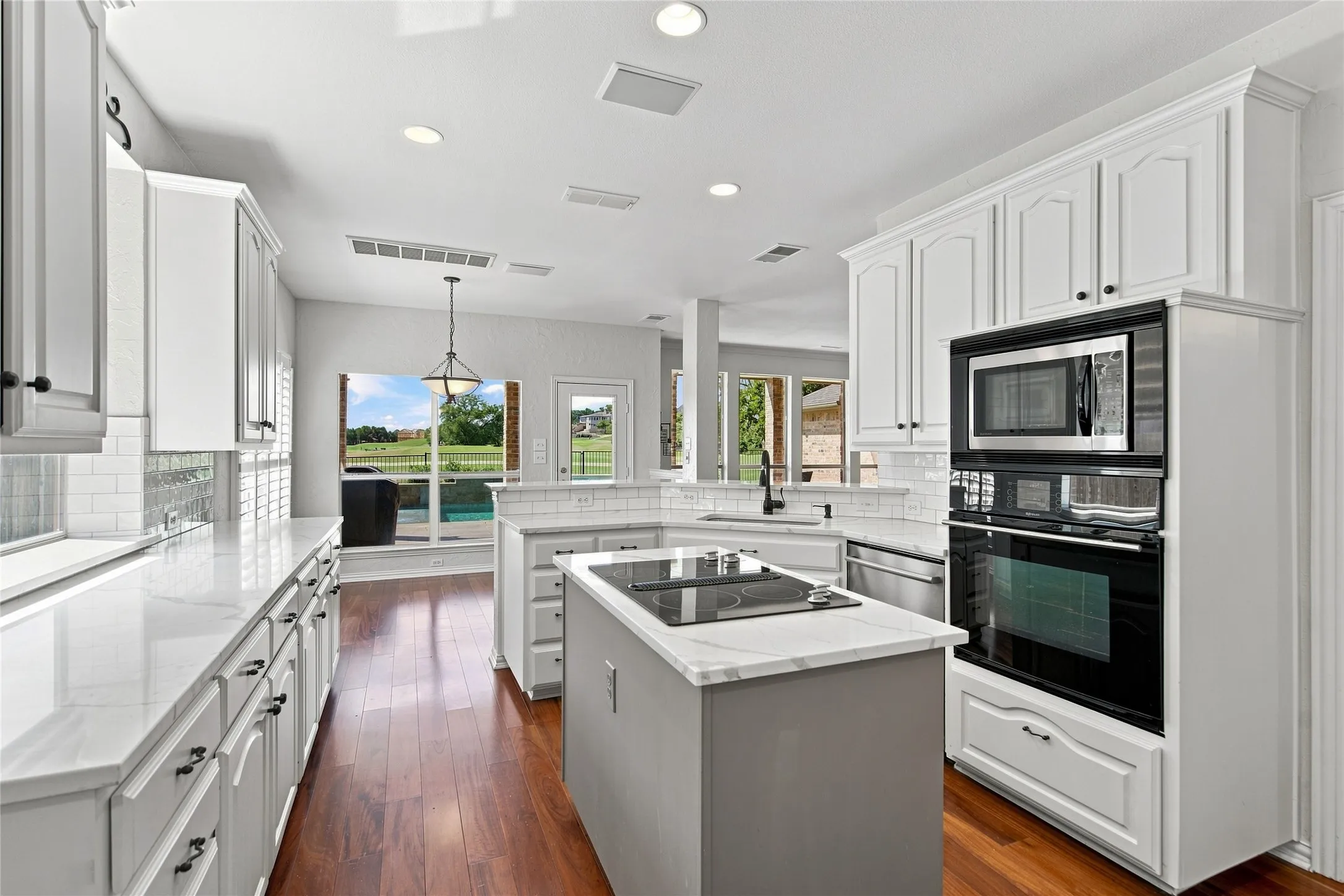 View from laundry and garage entry of kitchen with integrated stainless steel appliances.