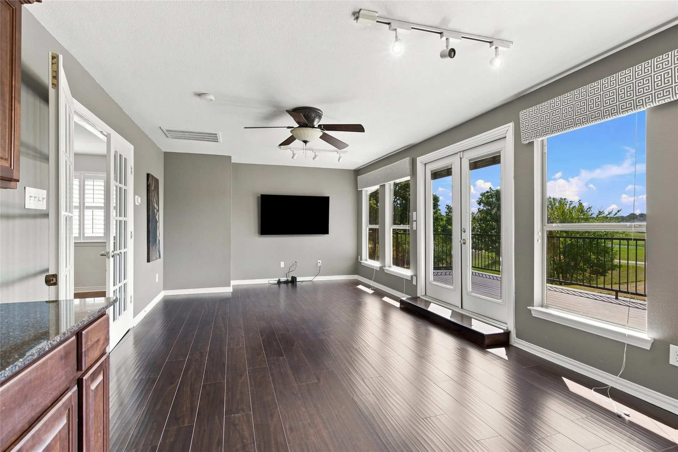 Spacious gameroom featuring views of the golf course and balcony access with a wet bar.