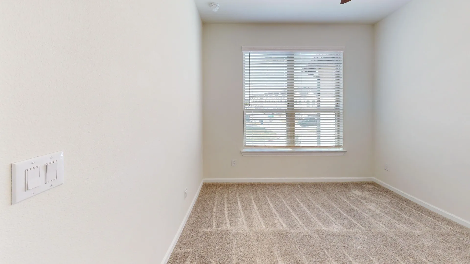 Neutral wall paint, ceiling fan, carpet flooring, and window with horizontal blinds