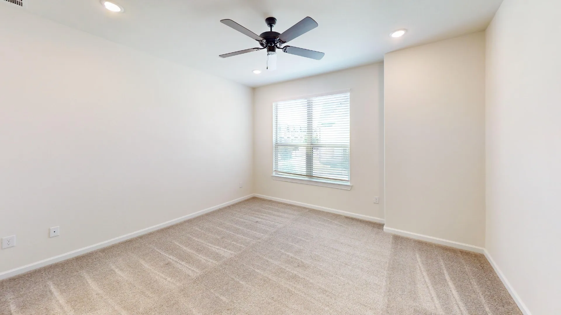 Recessed ceiling lighting, ceiling fan with light fixture, neutral tone carpeting, window with blinds, and light-colored wall paint