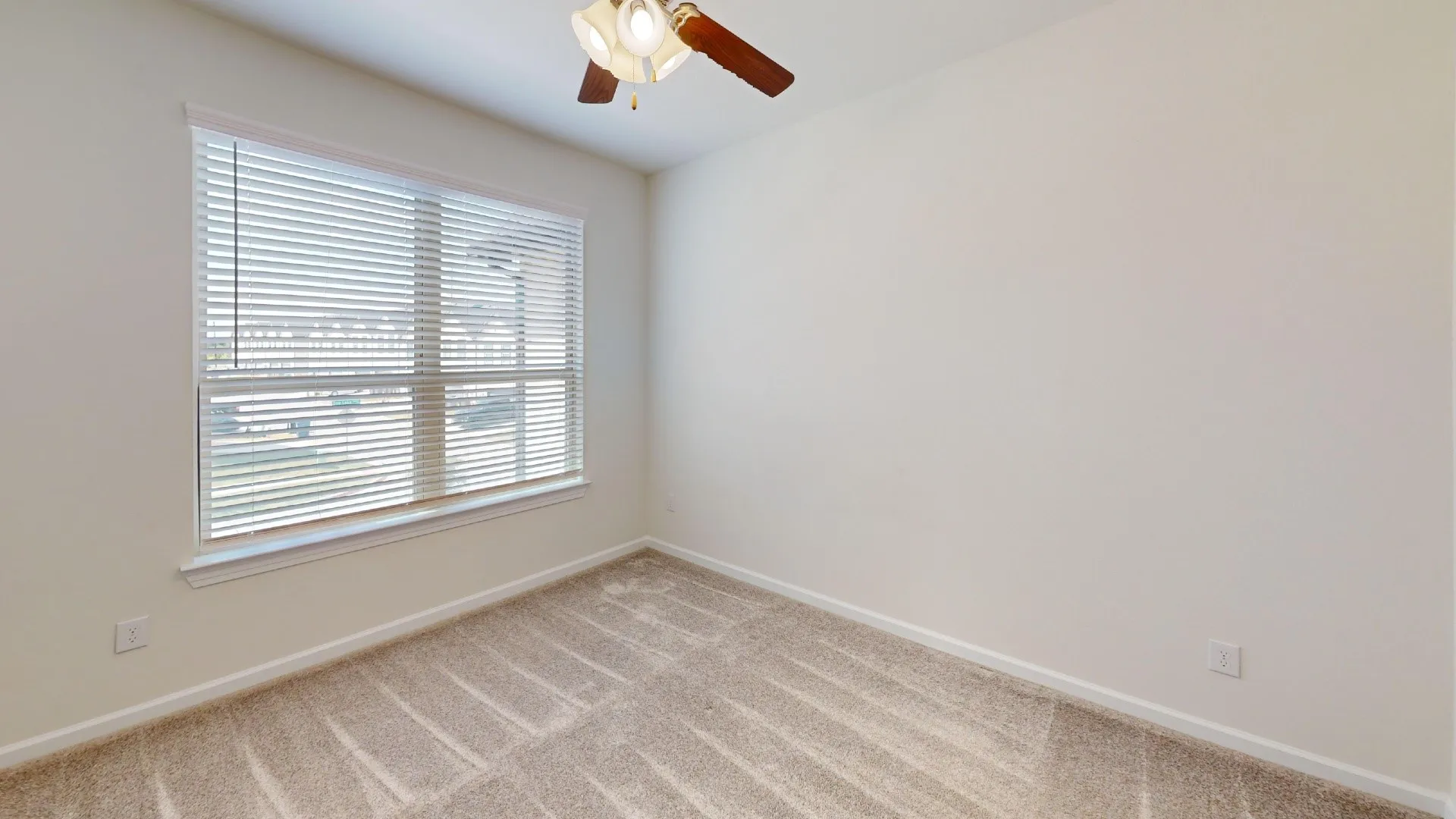Recessed window with blinds, overhead ceiling fan, and carpeted flooring