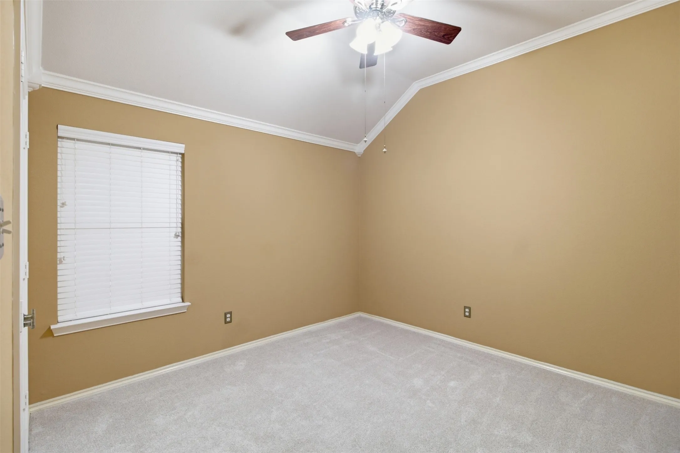 Vaulted ceiling with a ceiling fan, crown molding, light-colored carpeting, and a window with blinds