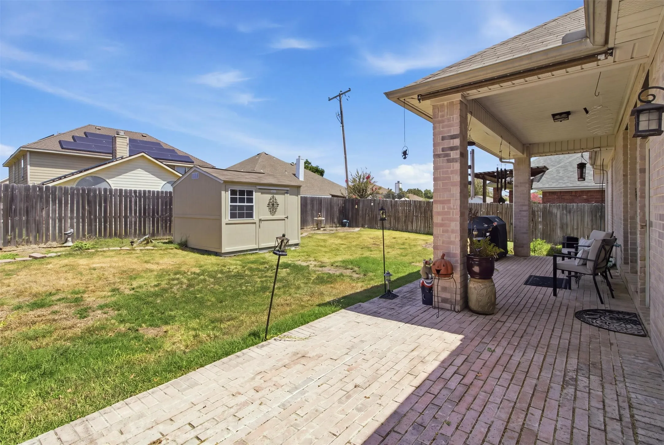 Covered patio with brick columns and exterior lighting