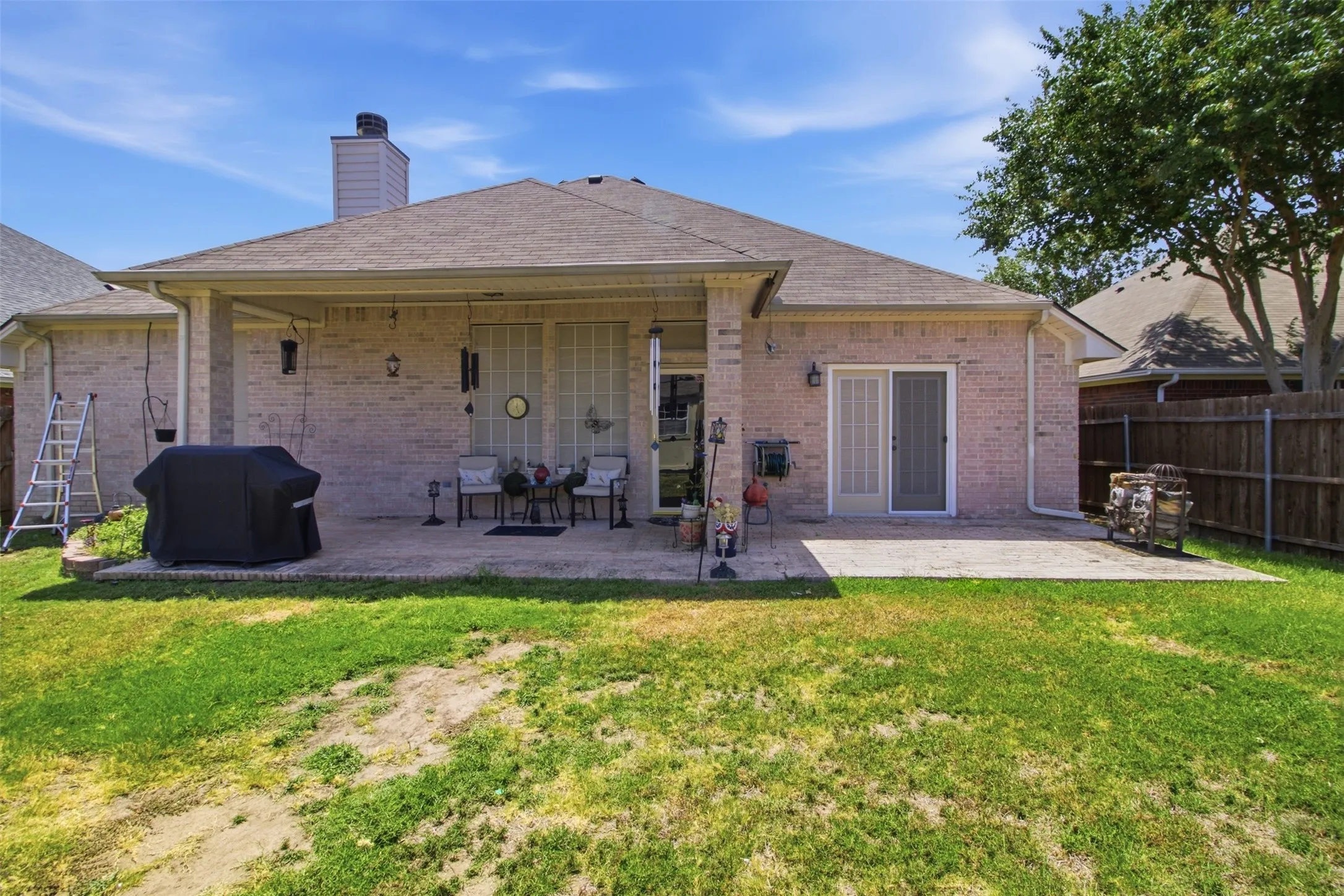 Brick exterior with a covered patio, additional patio space, and sliding glass door access