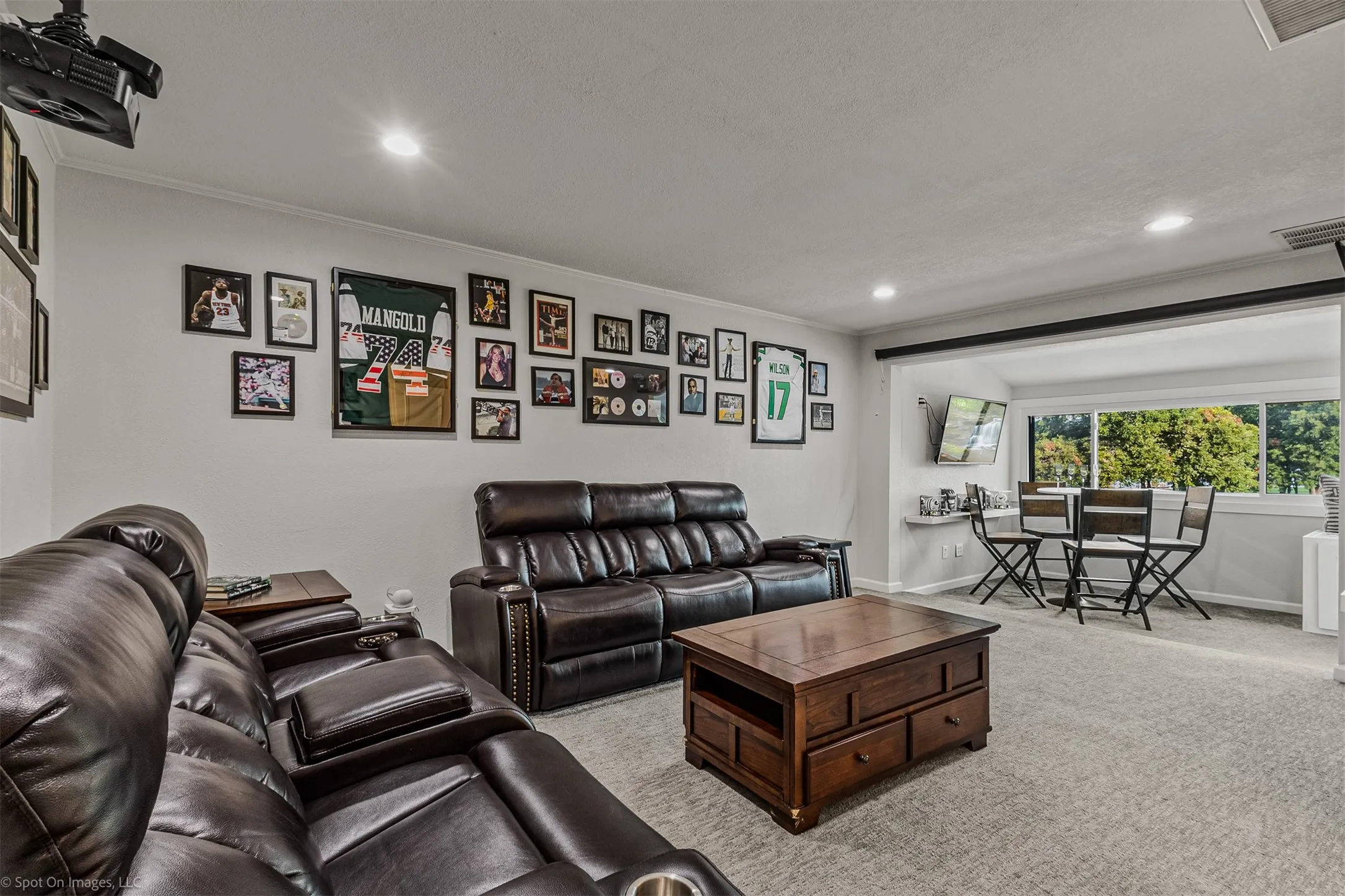 Recessed lighting illuminates the carpeted floor and painted walls