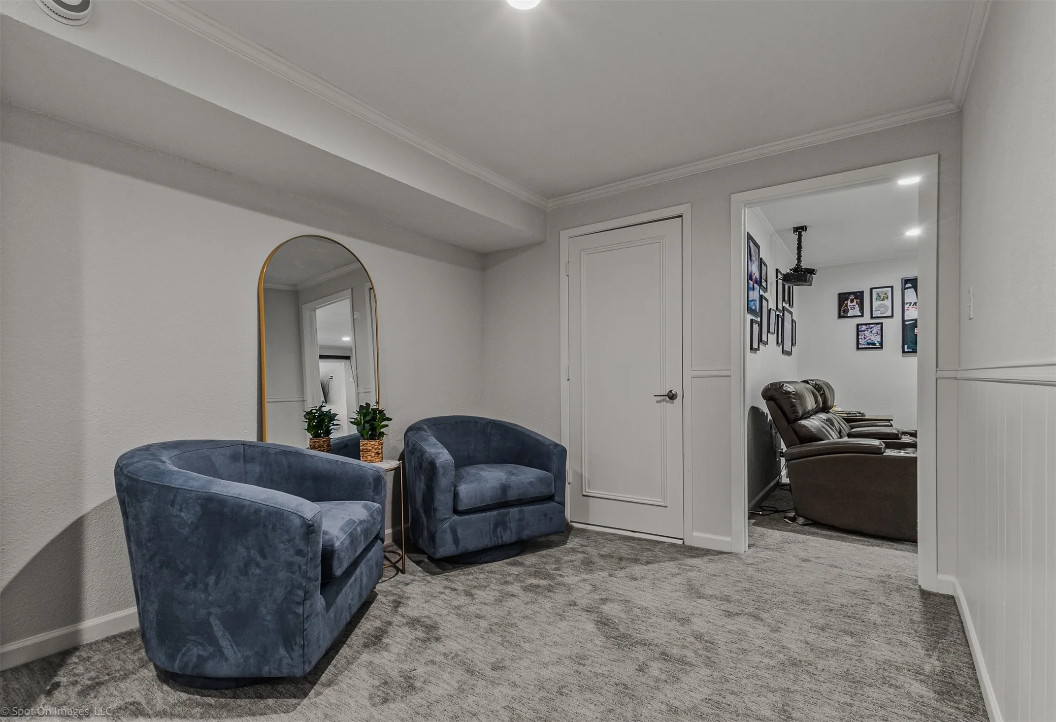 Arch-top mirror with a metallic frame, recessed ceiling lighting, and crown molding