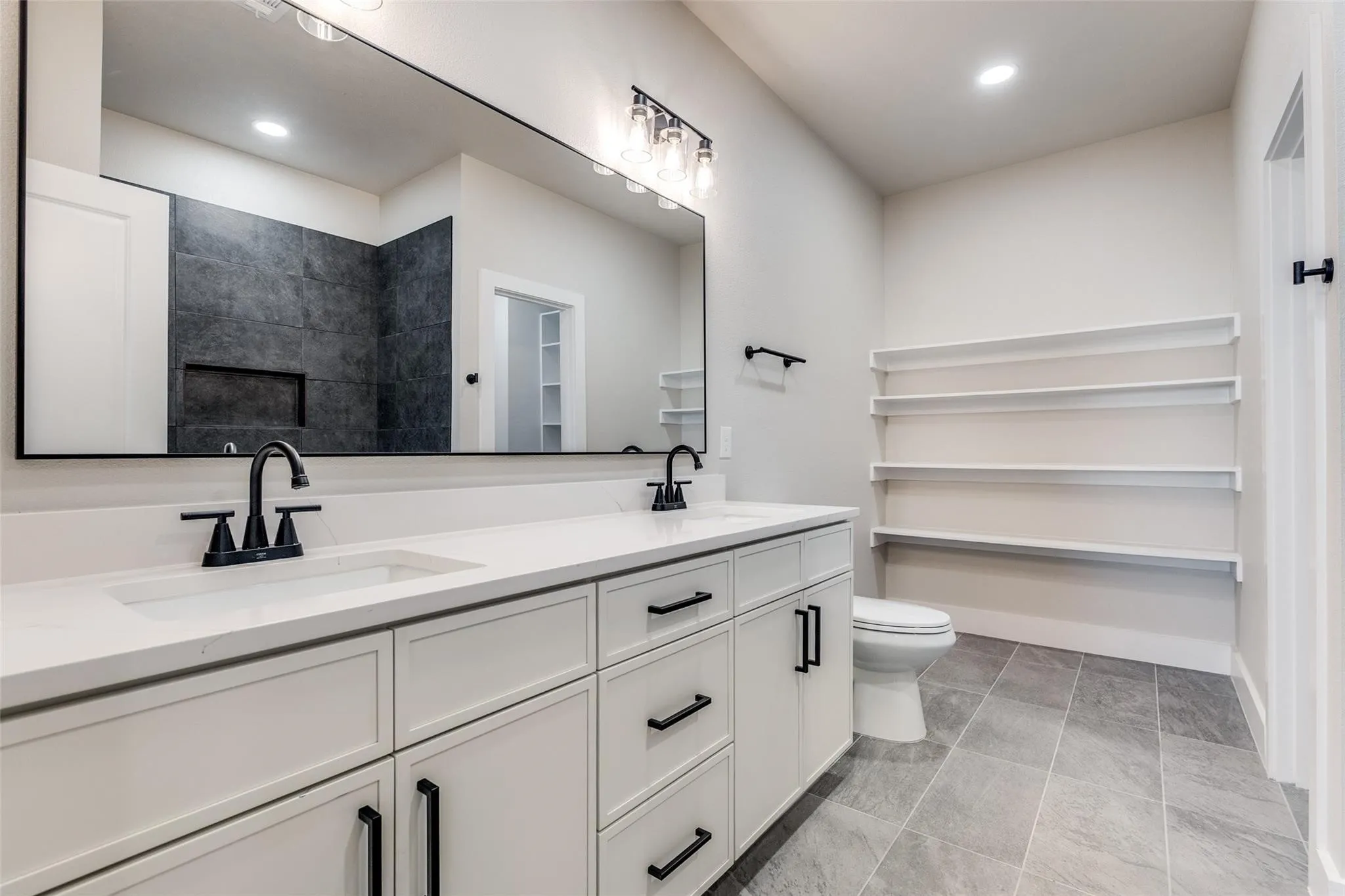 Dual vanity with integrated sinks, matte black fixtures, and white cabinetry