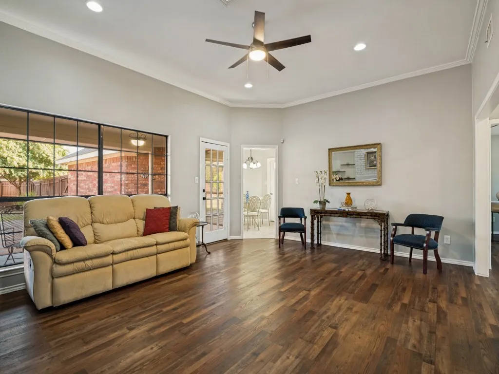 Spacious living area featuring wood-finish flooring, recessed lighting, and a ceiling fan
