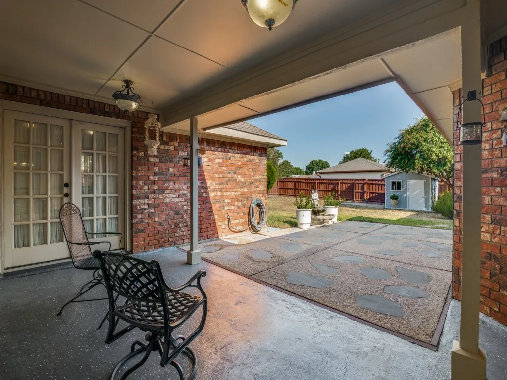 Covered patio featuring an exposed aggregate concrete surface with flagstone accents