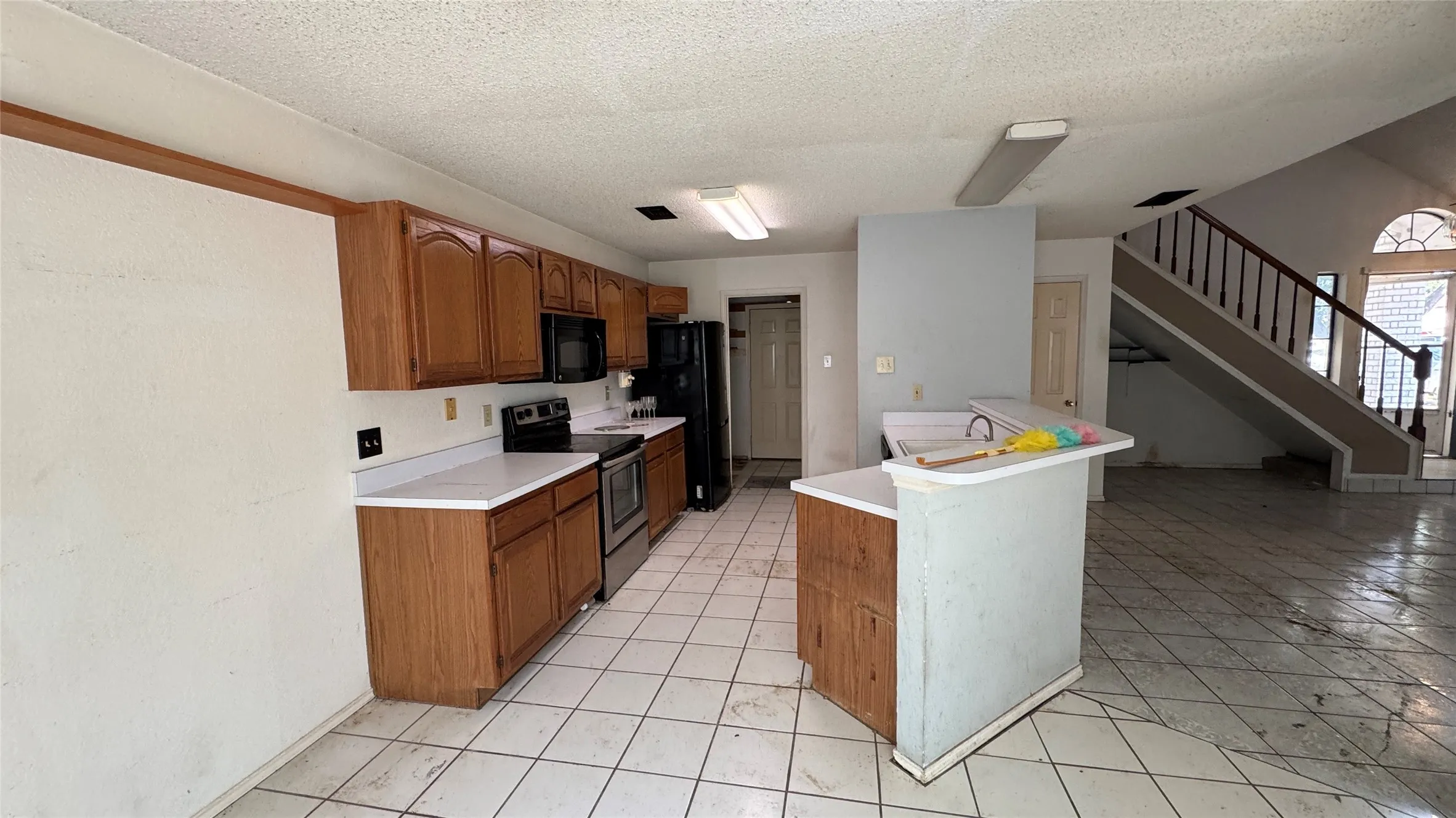 Kitchen with wood-finish cabinetry and white countertops