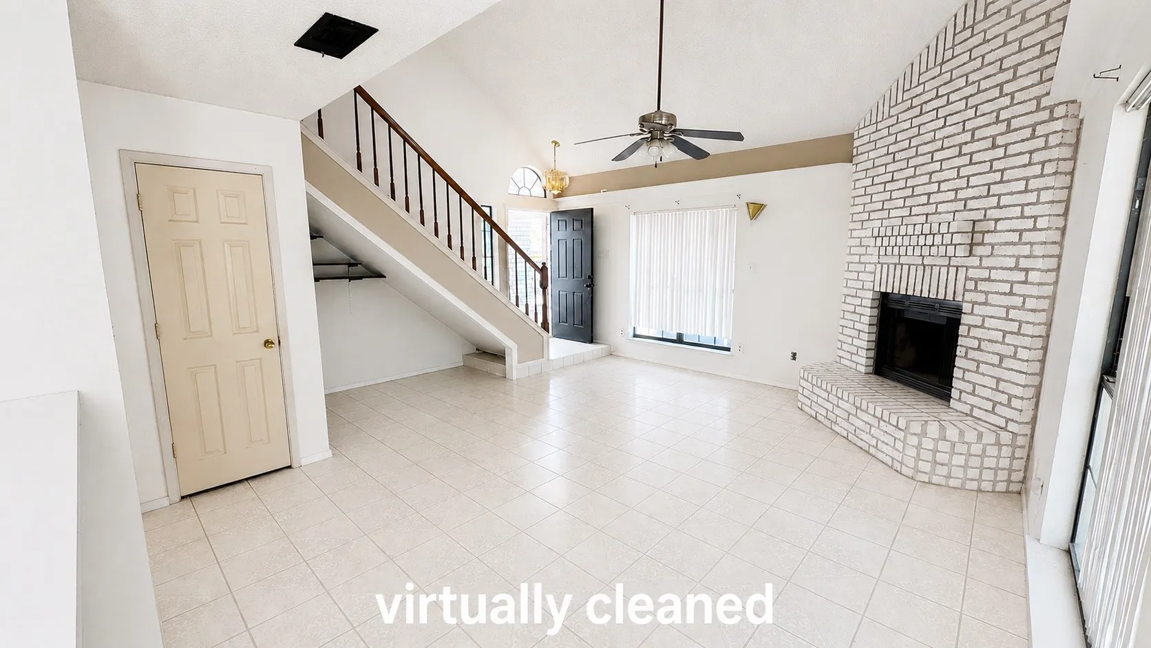 Vaulted ceiling with a ceiling fan, white brick fireplace, tile flooring, and a staircase with a wood railing