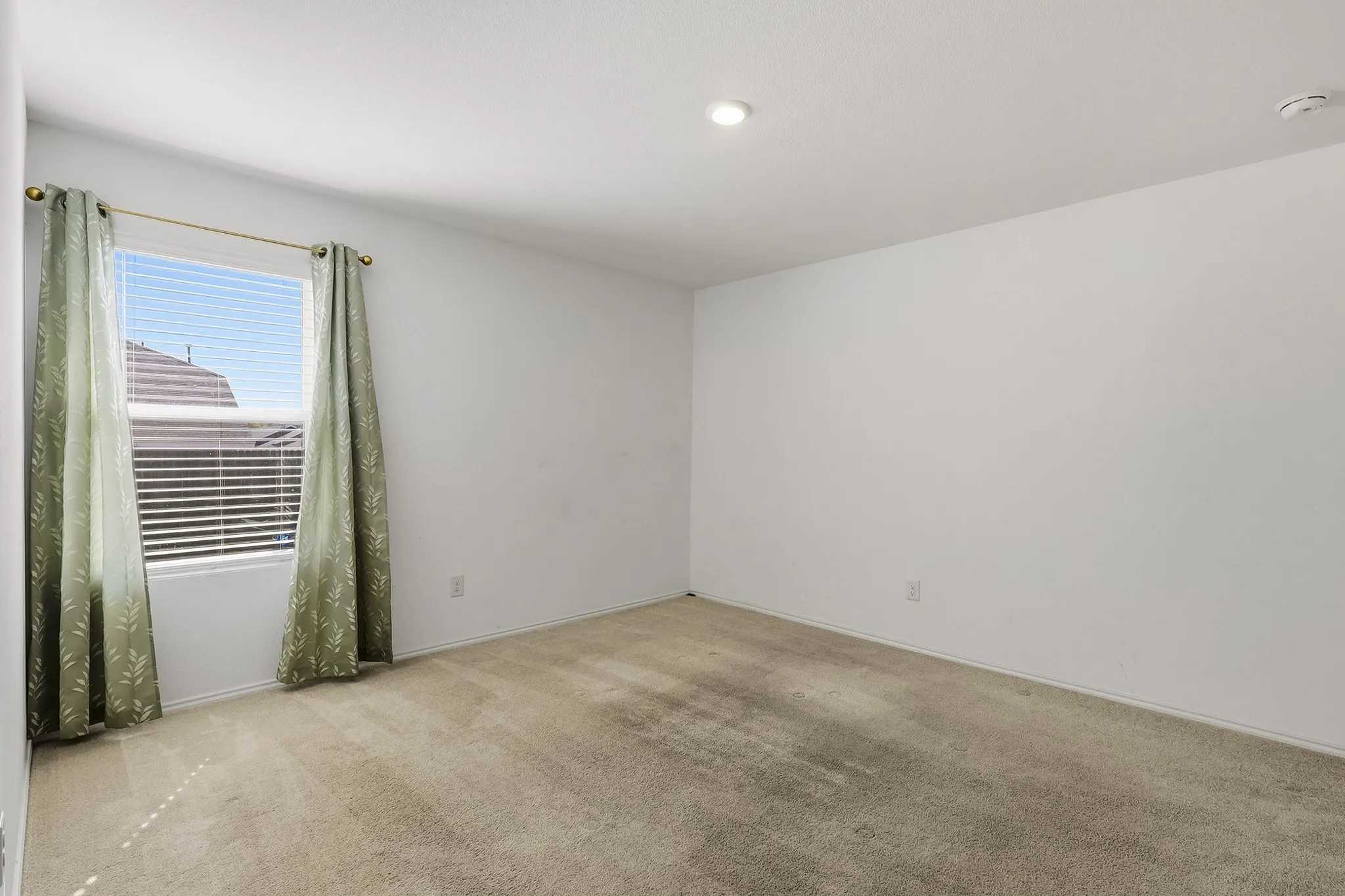 Recessed ceiling lighting complements the neutral wall color and carpeted flooring